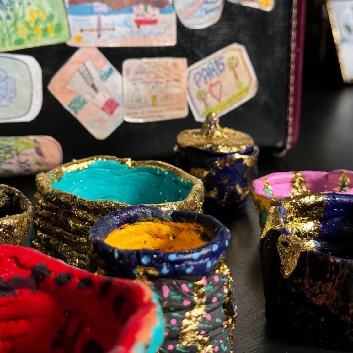 Small colourful handmade pots decorated with gold leaf.