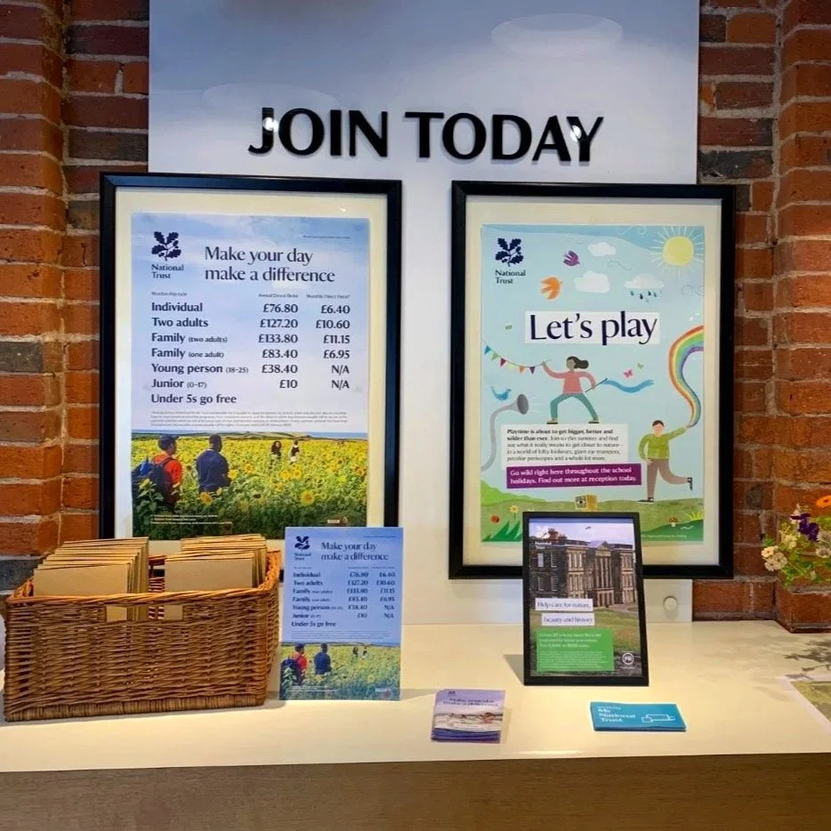 A desk displaying marketing materials advertising National Trust membership for Let's Play.