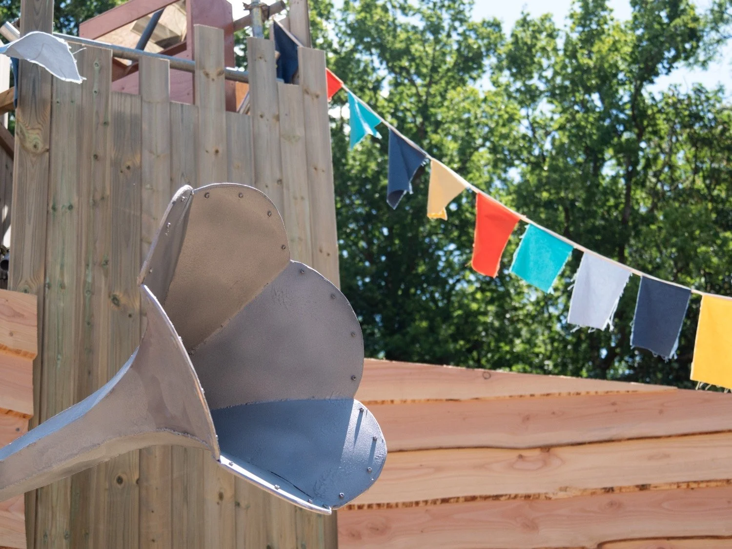 A silver megaphone with some colourful bunting in the background.