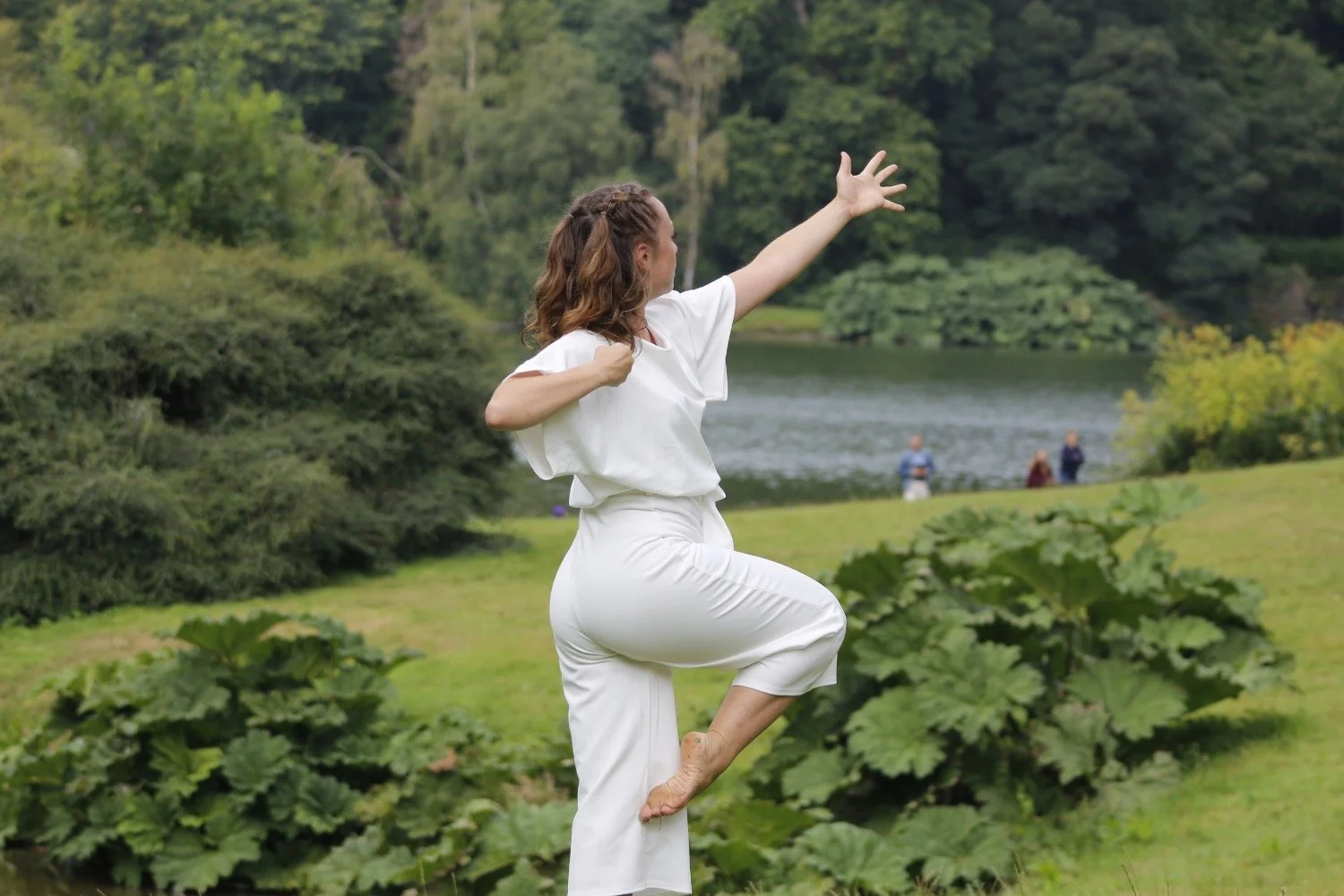 A brown-haired girl dances in the garden at Stourhead in Wiltshire.