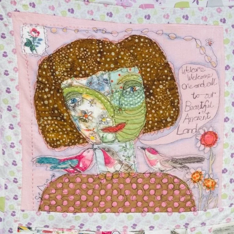 A fabric panel depicts a woman's face welcoming people to Cornwall.