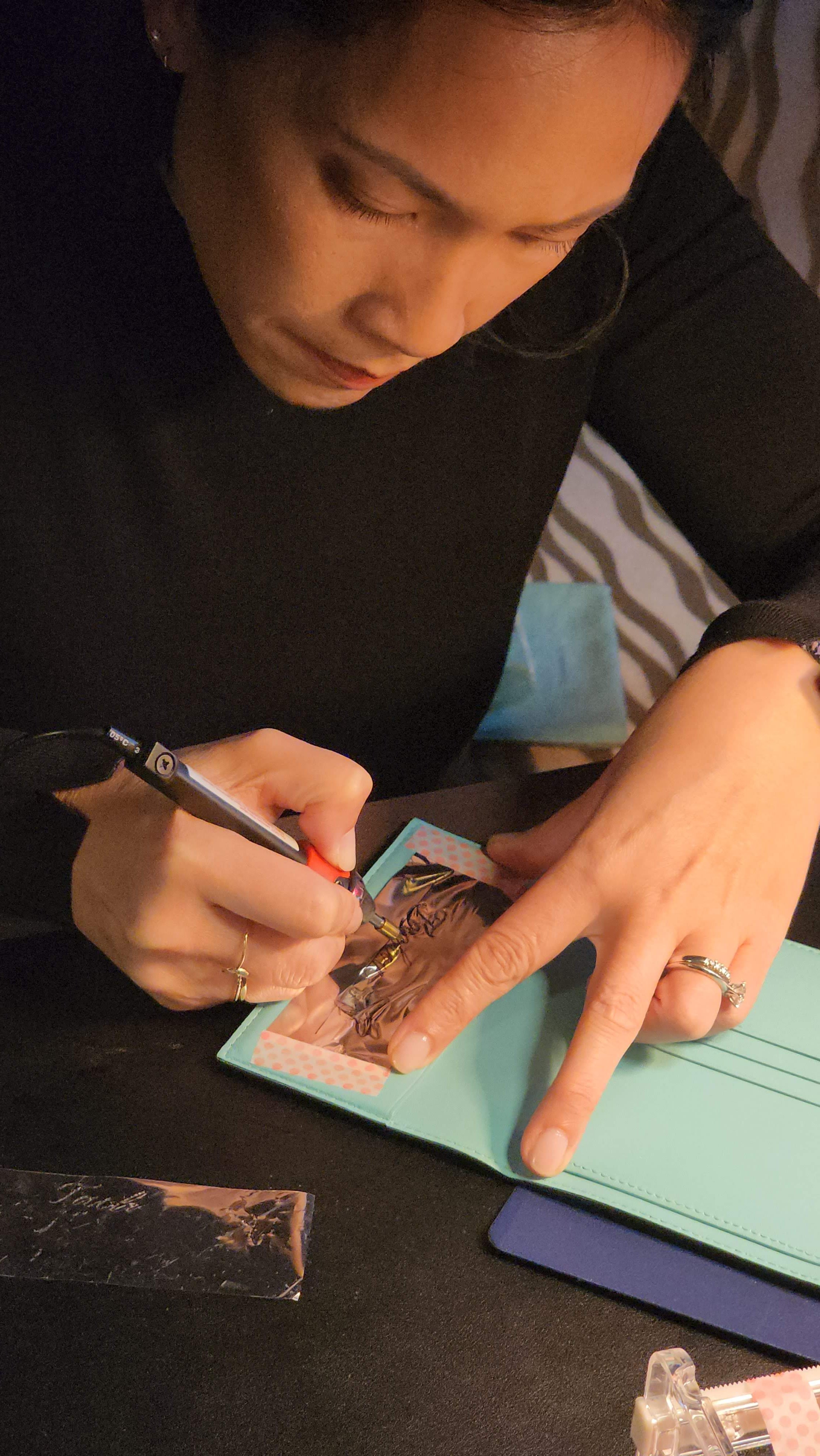 On-site luxury foiling on a passport cover and guest personalization at a hospitality brand activation event