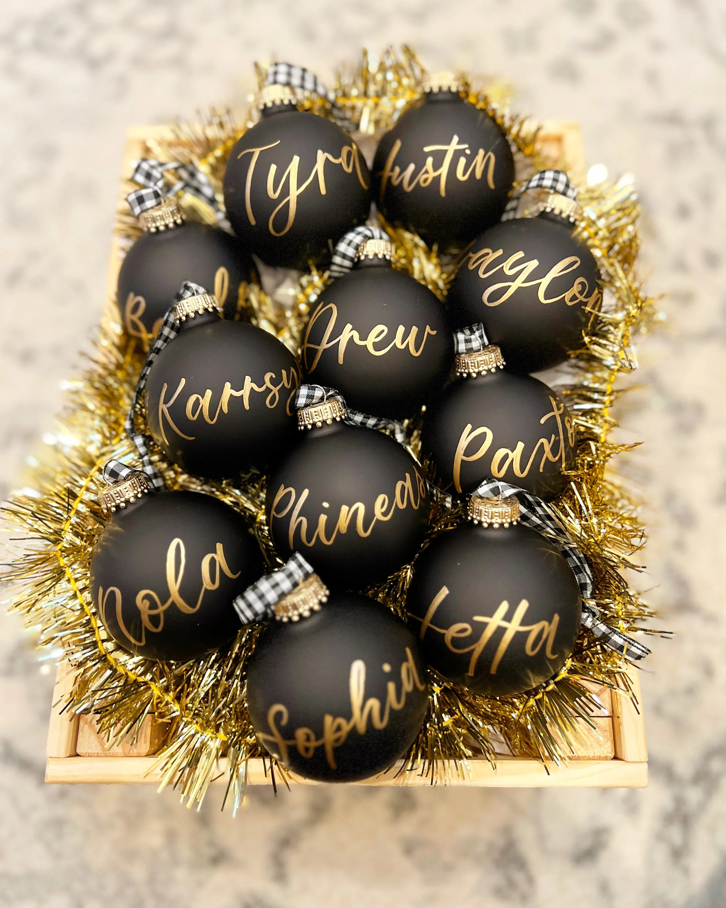 Black holiday ornaments with gold modern calligraphy personalization for luxury Christmas gifting and custom ornament calligraphy