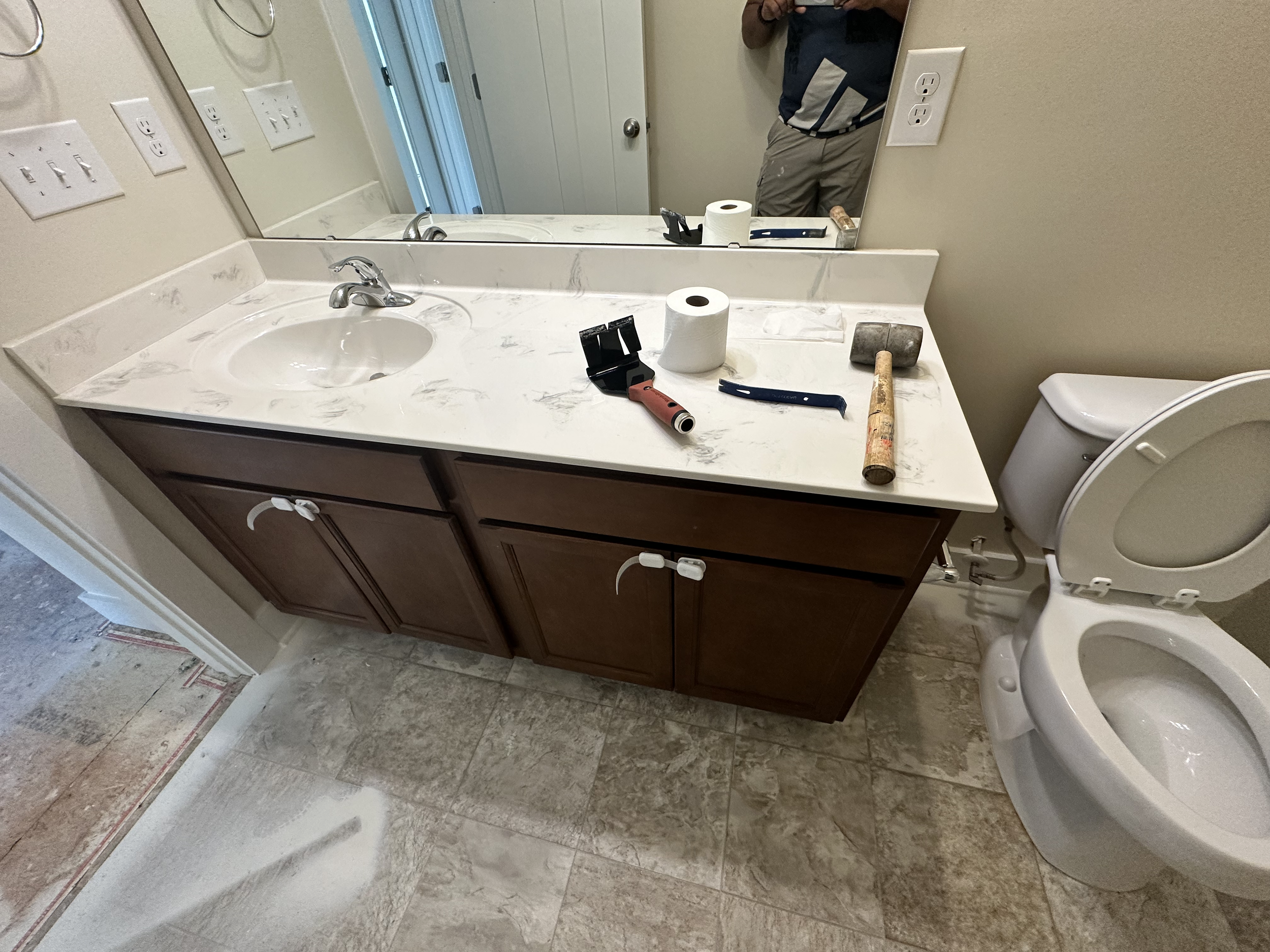 This vanity was removed, as well as the linoleum flooring. We installed porcelain 12x24 inch tile instead