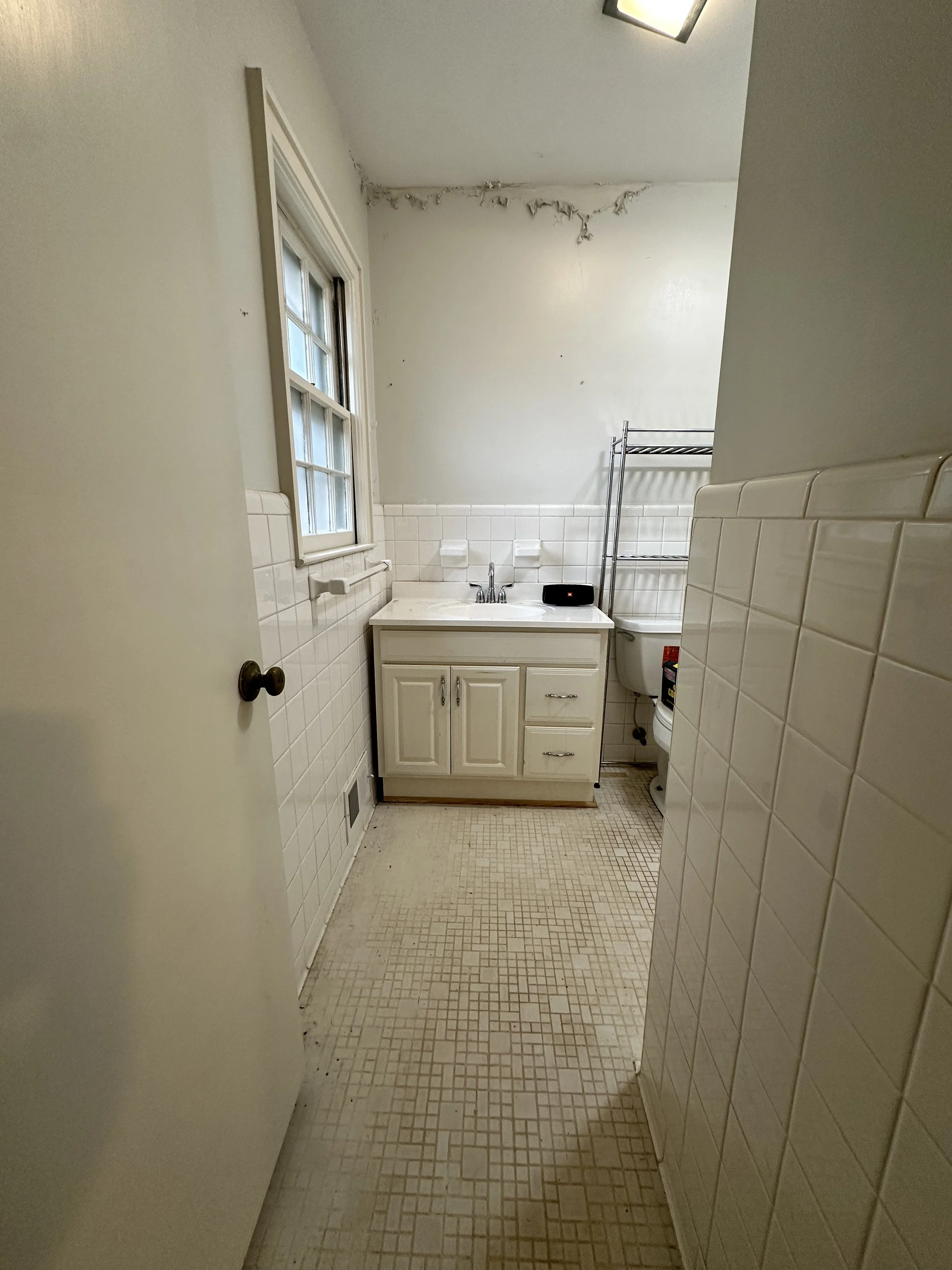 Original bathroom vanity and window with the traditional soap holder attached to the wall.