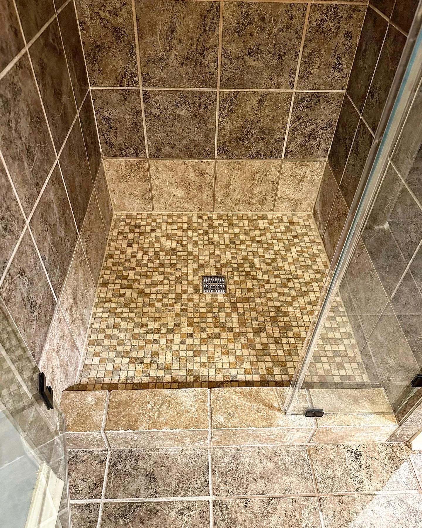 We installed these beautiful mosaic tiles as the shower base and replaced the last row of tile with some left over pieces they had for this shower. The reason the last row is a different color is because that tile is actually used elsewhere in this s