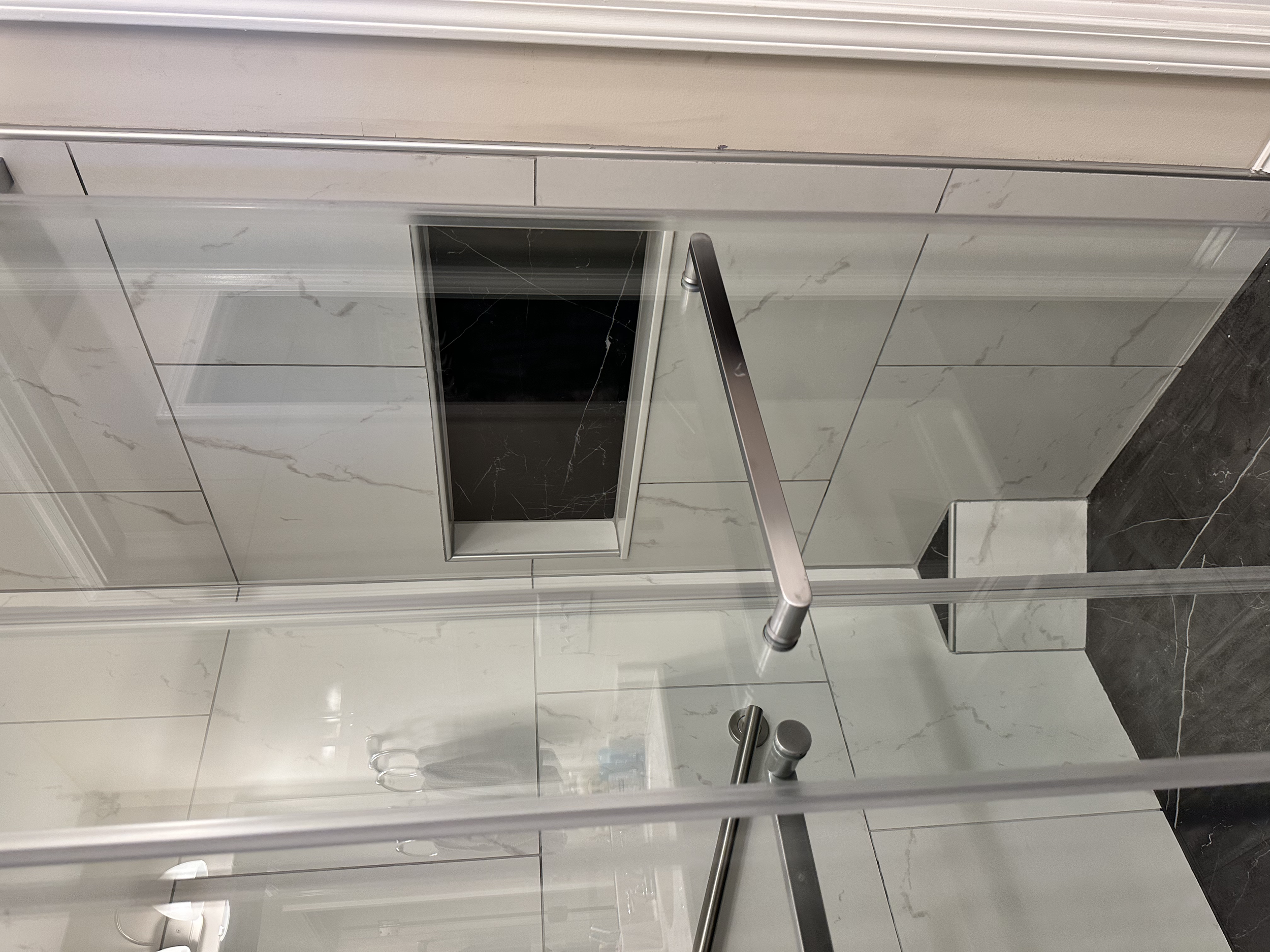 Sliding shower door installed with long handles for those who like to hang their towels on the door.