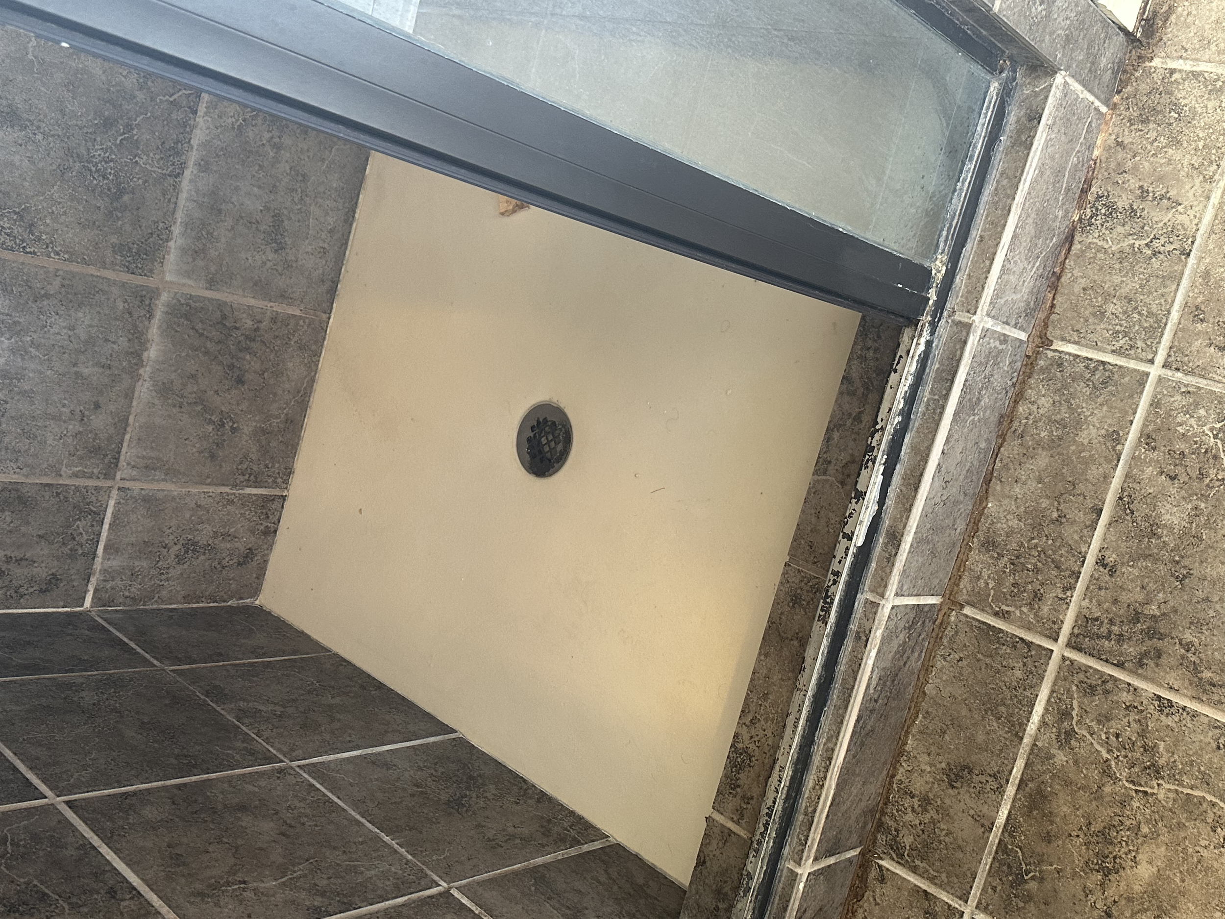 This shower pan was leaking under the shower door and underneath the tile of the shower curb. The customer called us to rebuild the shower pan and install a new frameless shower door. 
