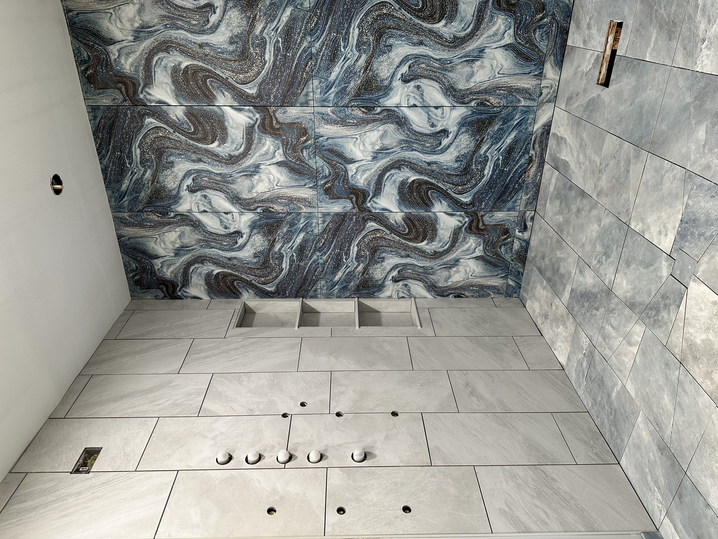 The floor and walls have 12x24 inch porcelain tile and the accent wall has 24x48 inch porcelain tile.