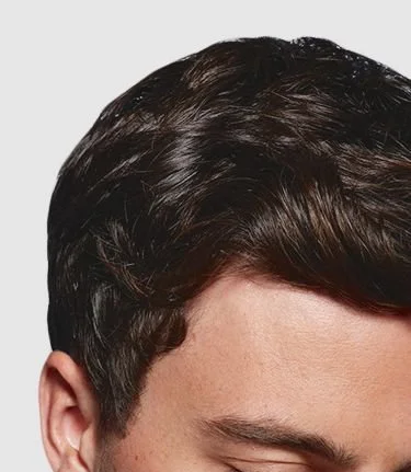 Close-up of a person's head with dark, shiny, short hair, focusing on the hair and scalp.