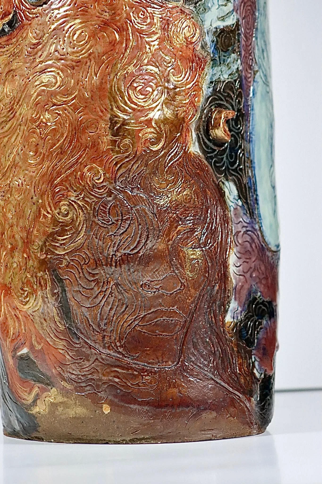 “Rebirth”, 2025. Red stoneware clay with sgraffitto,  black and porcelain slips, malcolm shino, red irwing, peach bloom 2, cuba's beaches, purple haze, and gold acrylic paint.
9" x 23" inches. 
The ceramic vase displays a narrative story of rising fr
