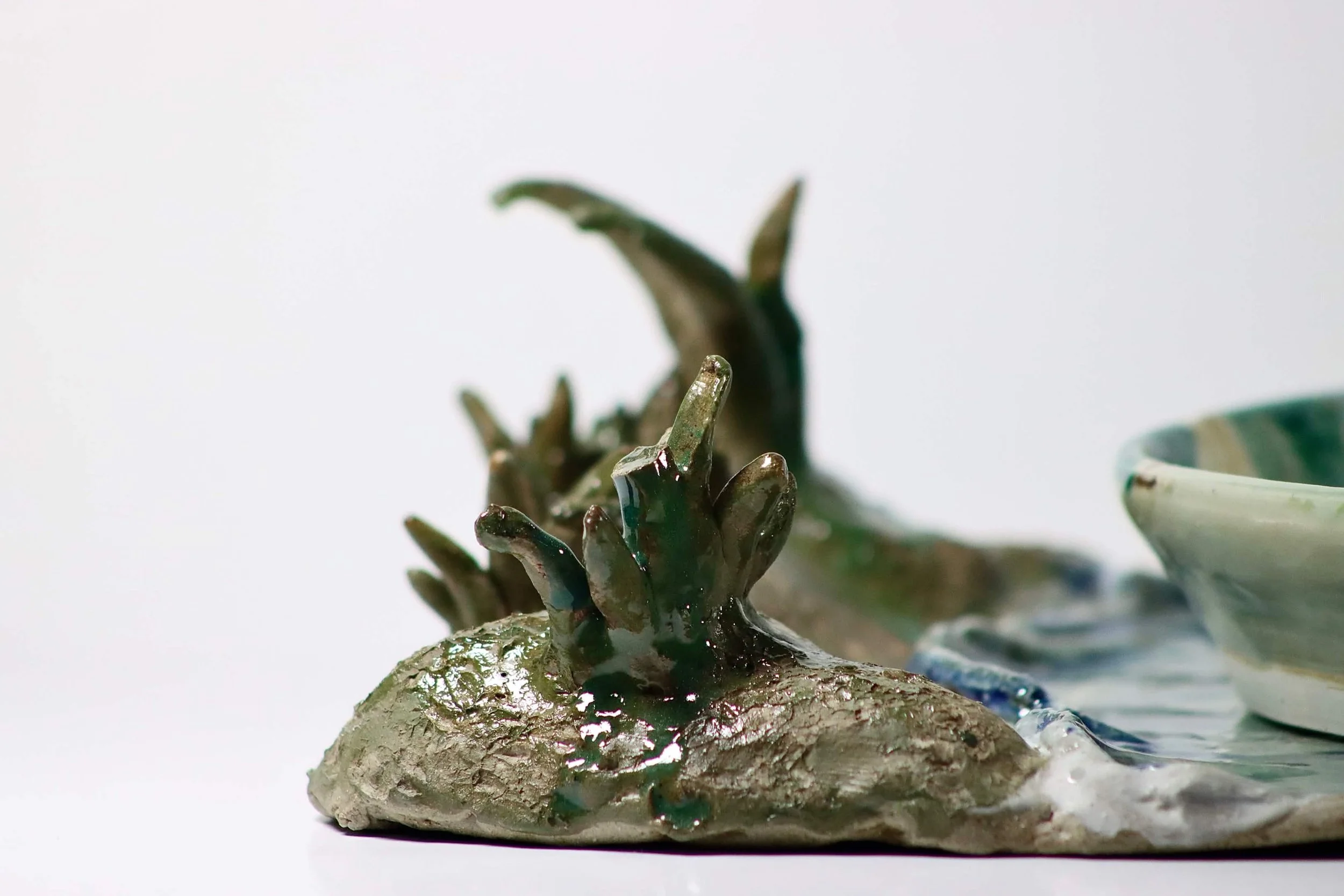 "My Rushing Waves of Culture II", 2026. Glazed Red Stoneware and Porcelain. 10.75" x 8.25" inches.

 Part of a series . A ceramic plate with a tray in the form of a lake showcasing my mother in San Jose, Peru cradling a sheep.