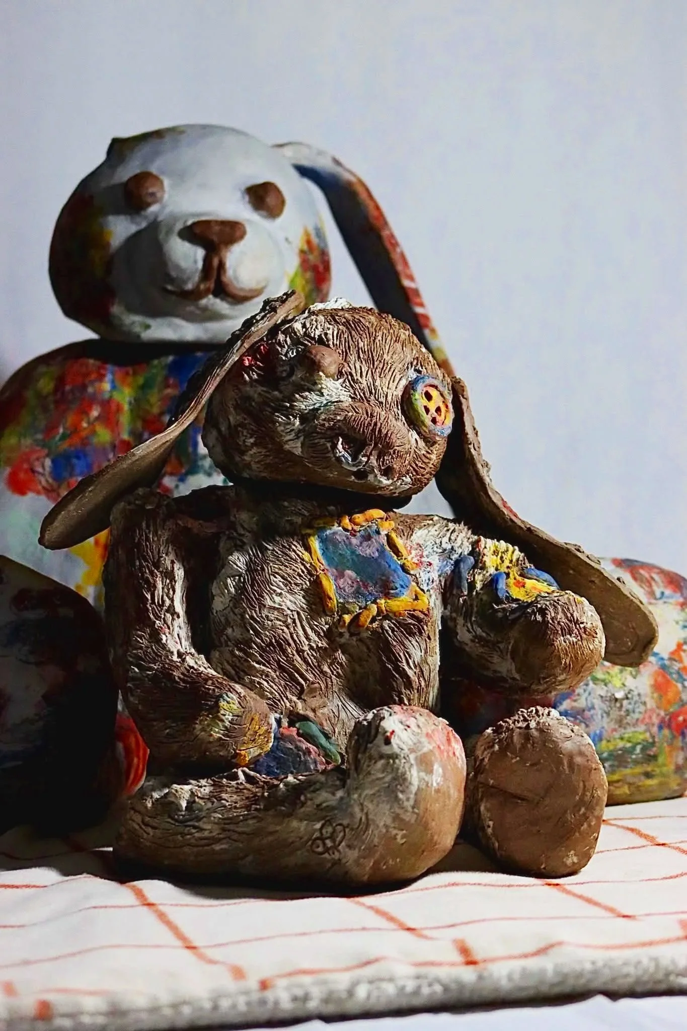 "Repatching My Inner Childhood", 2025. 

Red stoneware clay, Porcelain slip, Underglaze paint and crayons.
22" x 24" and 14" x 8".                                                                
Preserving my precious childhood memories by repatching