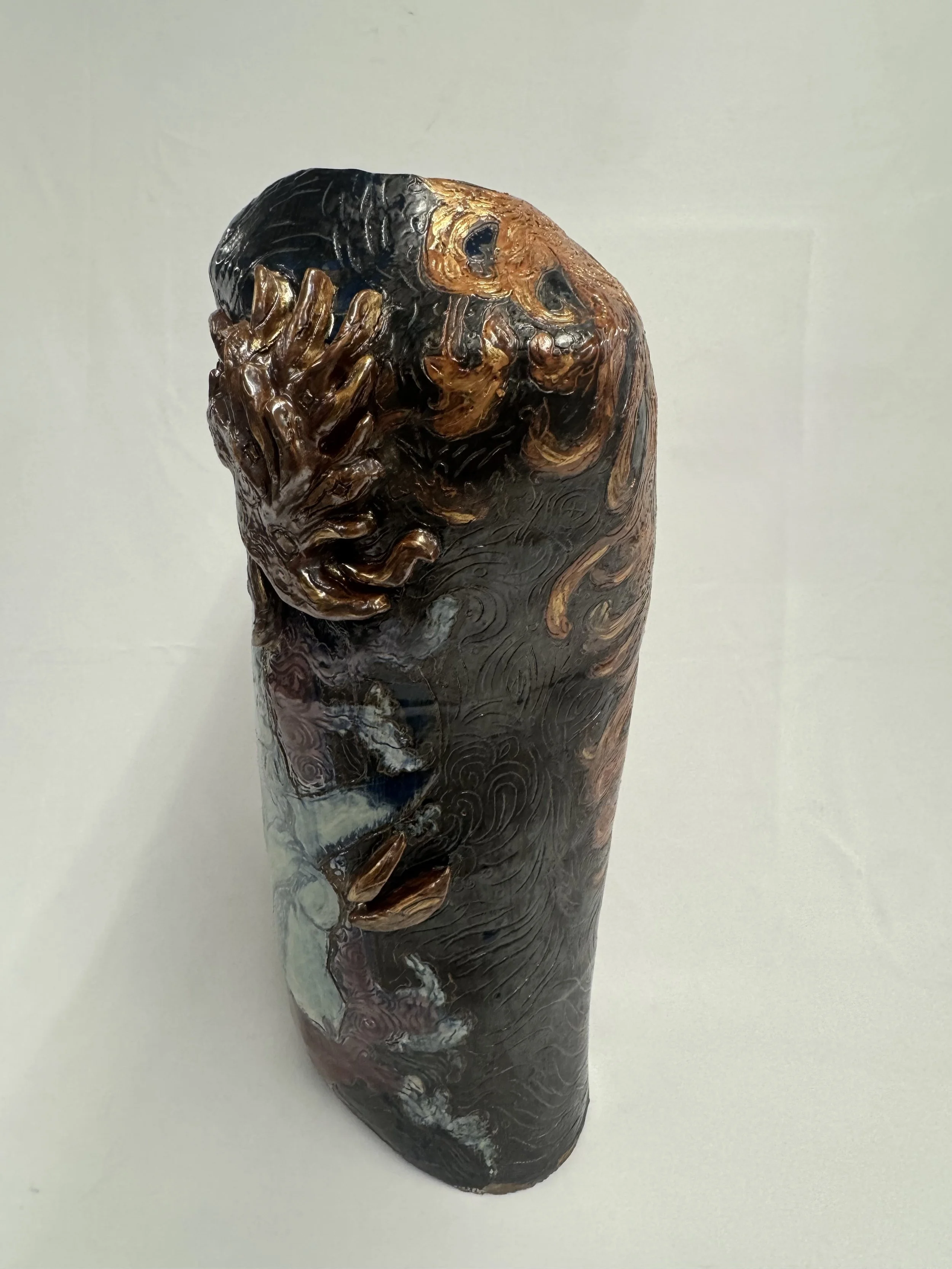 “Reborn Again”, 2025. Red stoneware clay with sgraffitto,  black and porcelain slips, malcolm shino, red irwing, peach bloom 2, cuba's beaches, purple haze, and gold acrylic paint.
9" x 23" inches 