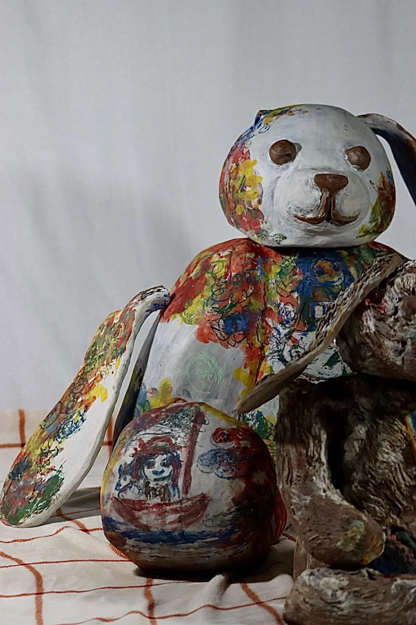 "Repatching My Inner Childhood", 2025. 

Red stoneware clay, Porcelain slip, Underglaze paint and crayons.
22" x 24" and 14" x 8".                                                                
Preserving my precious childhood memories by repatching