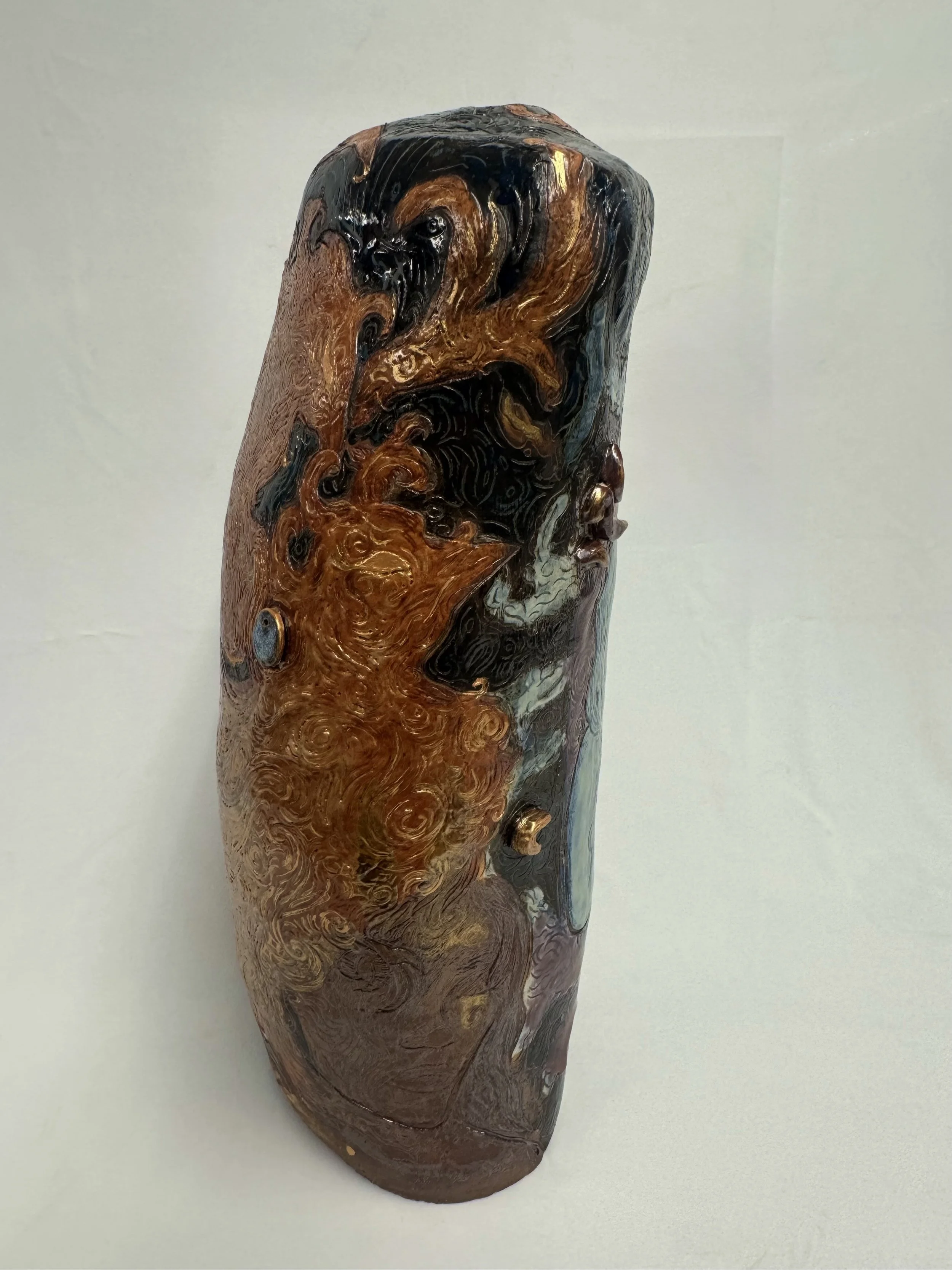 “Reborn Again”, 2025. Red stoneware clay with sgraffitto,  black and porcelain slips, malcolm shino, red irwing, peach bloom 2, cuba's beaches, purple haze, and gold acrylic paint.
9" x 23" inches 