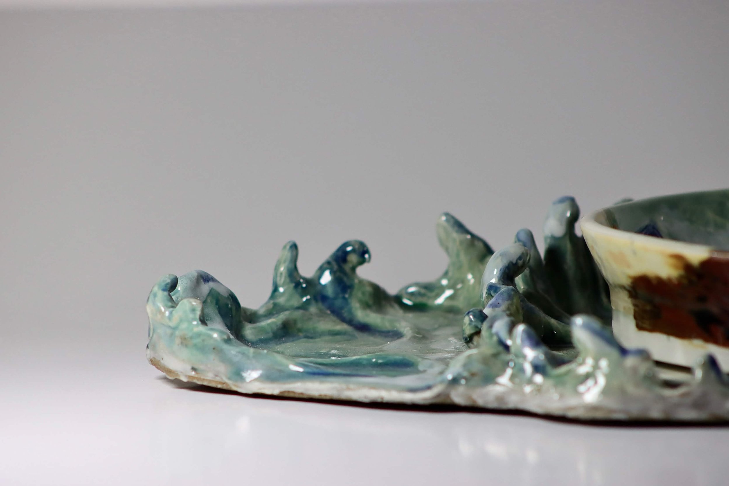 "My Rushing Waves of Culture III" 2026.  Glazed Porcelain. 11" x 8" inches.  Part of a series.  A ceramic plate of Miami Beach's shoreline on a tray in the form of ocean waves.