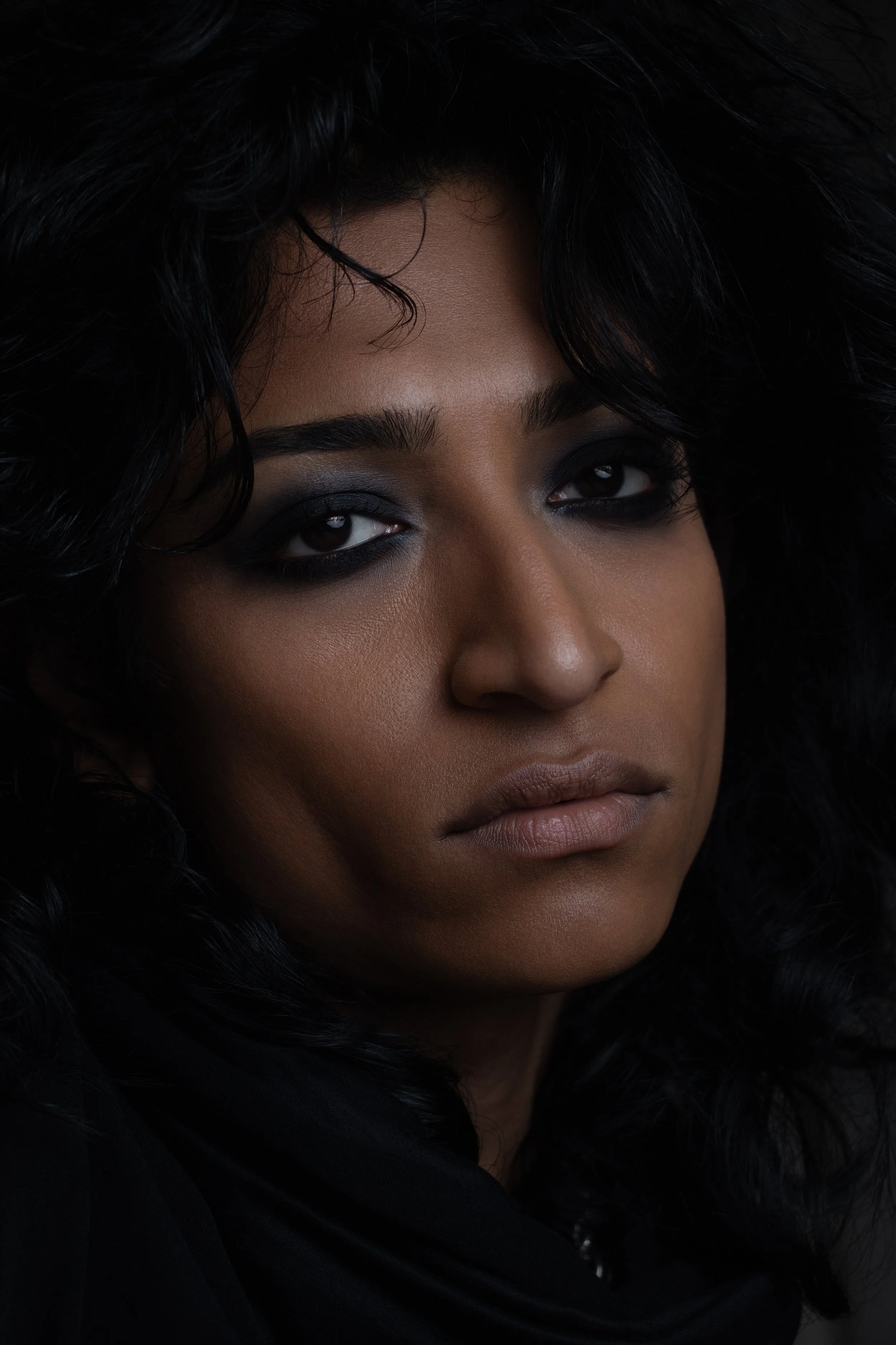 A sharp beauty portrait balancing softness, shadow, and controlled intensity