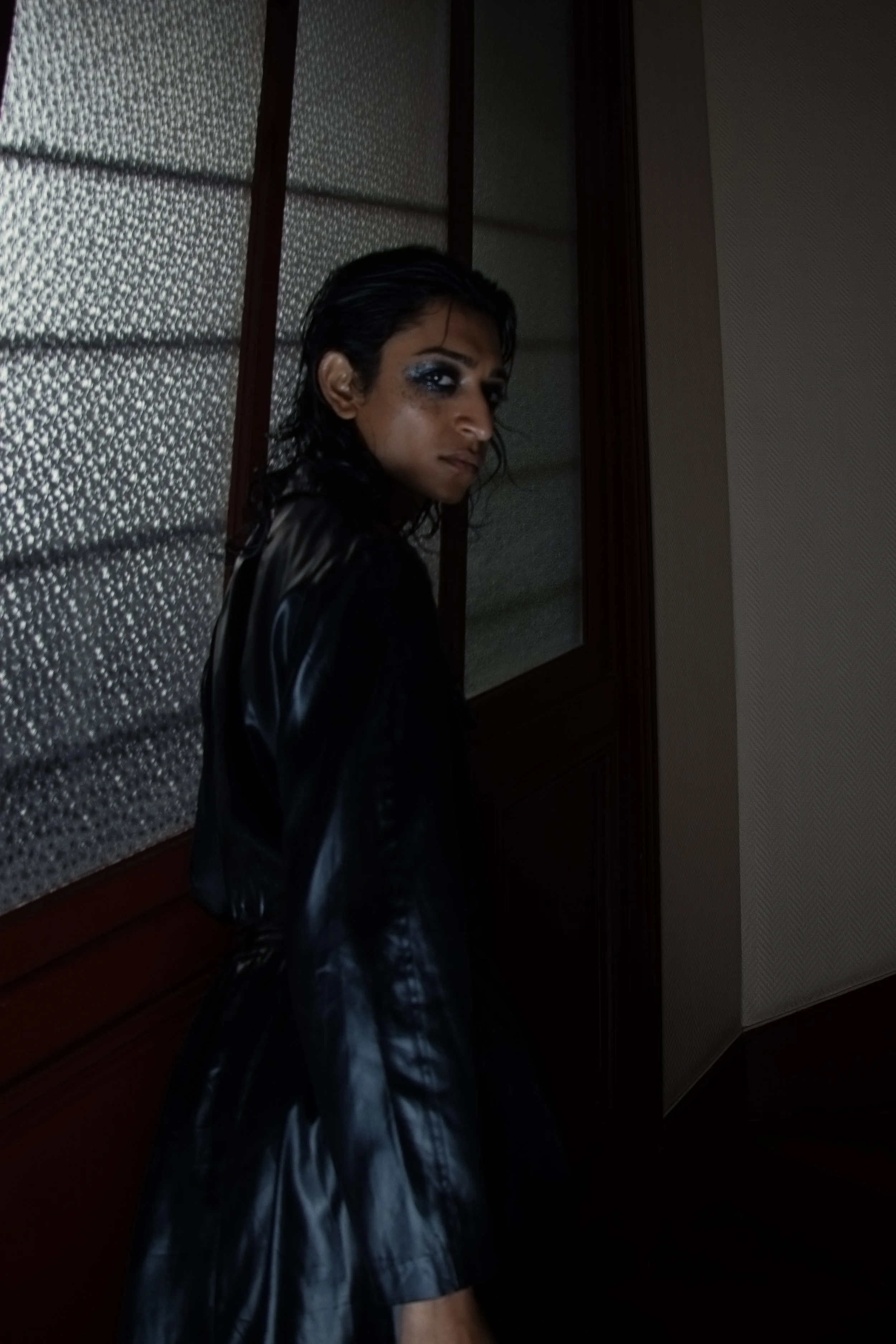 Shadowy lighting and slicked-back hair blur softness with quiet intensity