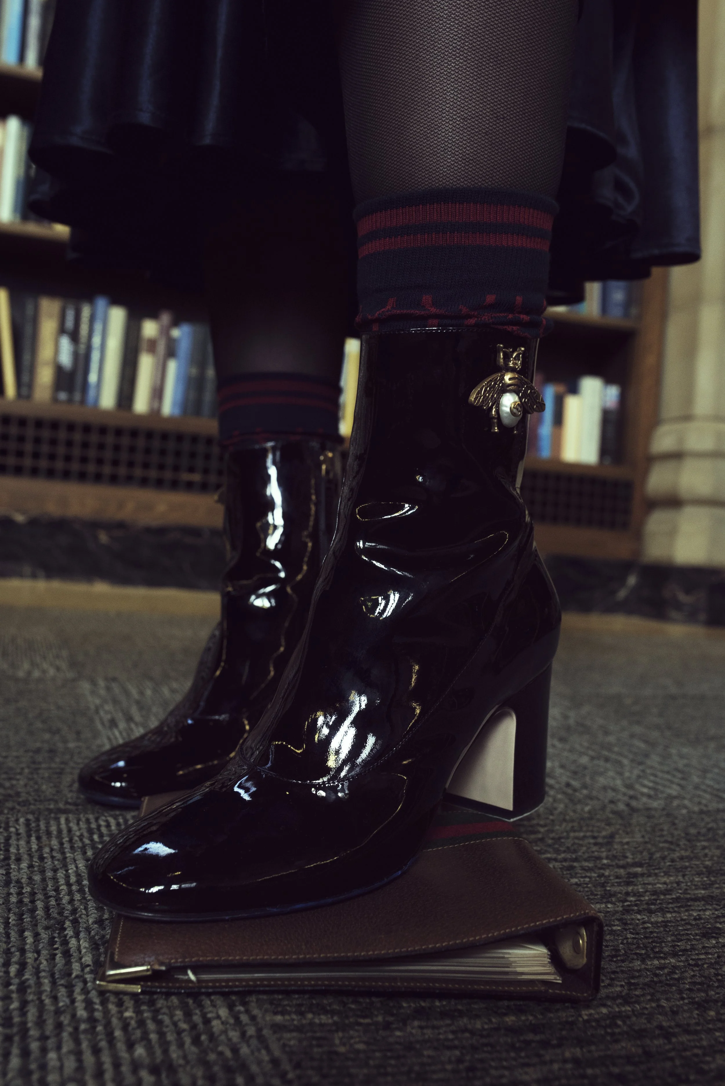   Wardrobe Credits    Skirt - No Label - Navy Blue Satin Flare Skirt from the 1970s courtesy of Red Light Vintage Tights - Hue or Stylist's Own - Black Sheer Tights Socks – Lorenzo Boots - Gucci - 'Lois' Bee Bootie  