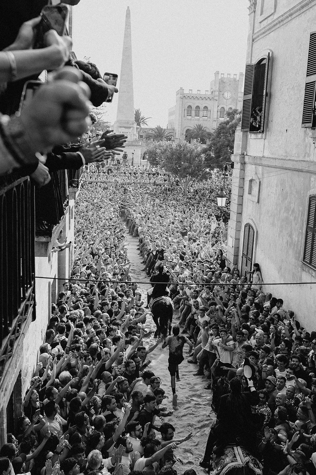 Participant running behind the Caixer Senyor at the start of the Caragol des Born in Ciutadella, Menorca, one of the most exciting events of Sant Joan