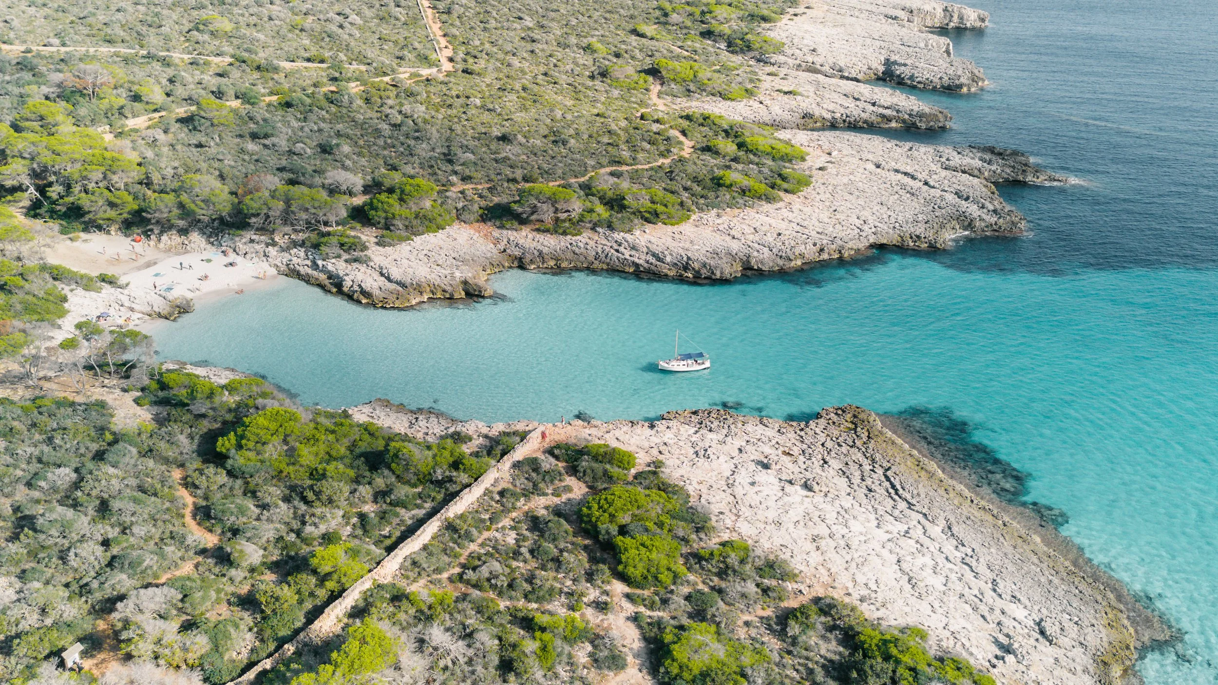 Traditional Menorcan llaut in a peaceful cove in Menorca