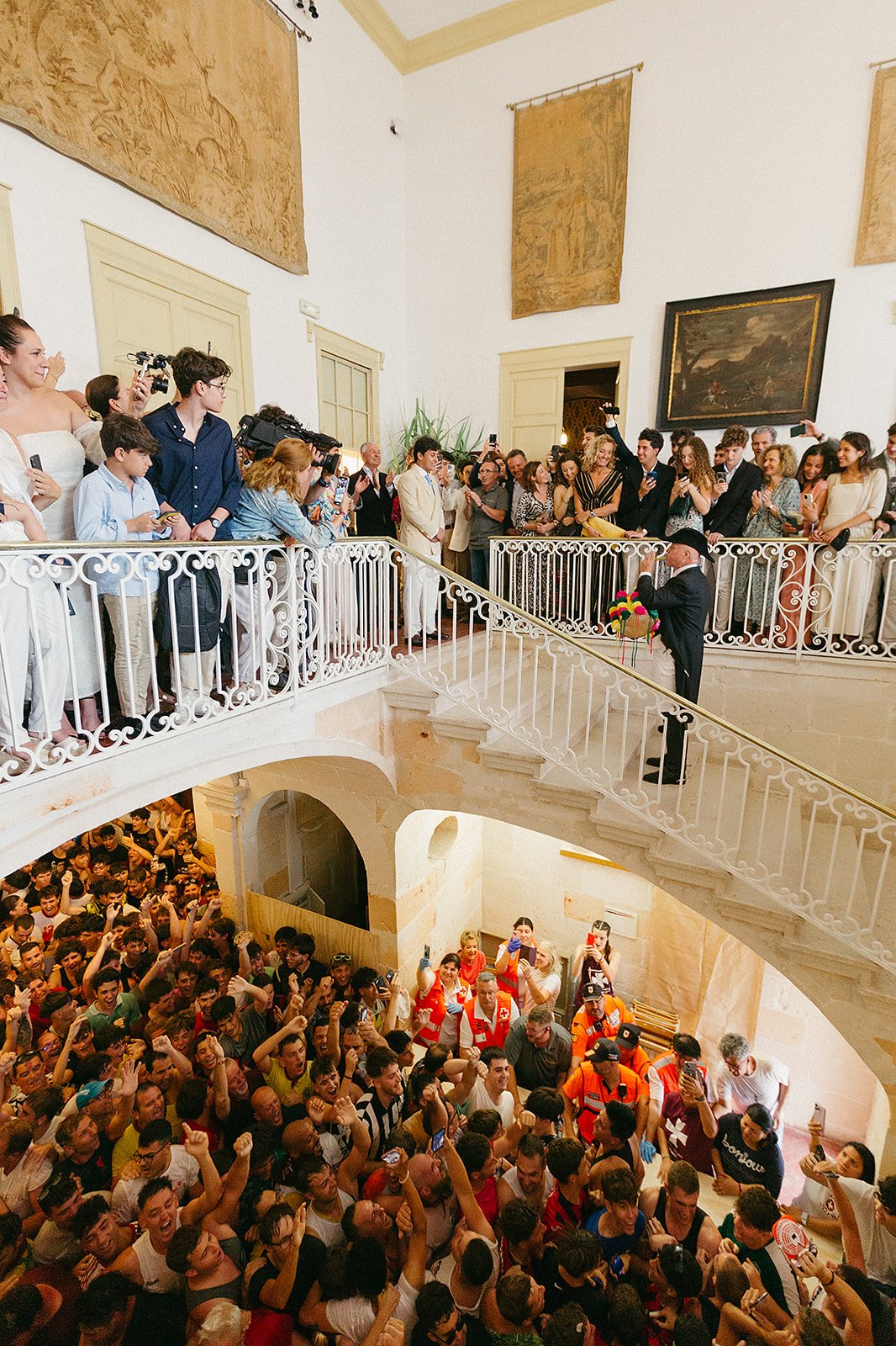 Fabioler playing the primer toque del fabiol in front of the Caixer Senyor during Sant Joan festival in Ciutadella, Menorca, with the crowd cheering below