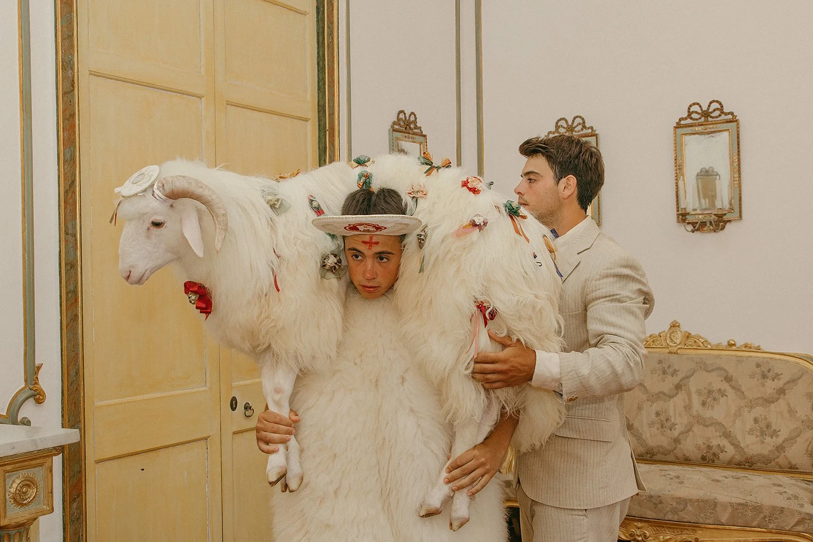 Man dressed in sheepskins carrying a lamb during Diumenge des Be, Sant Joan festival in Ciutadella, Menorca