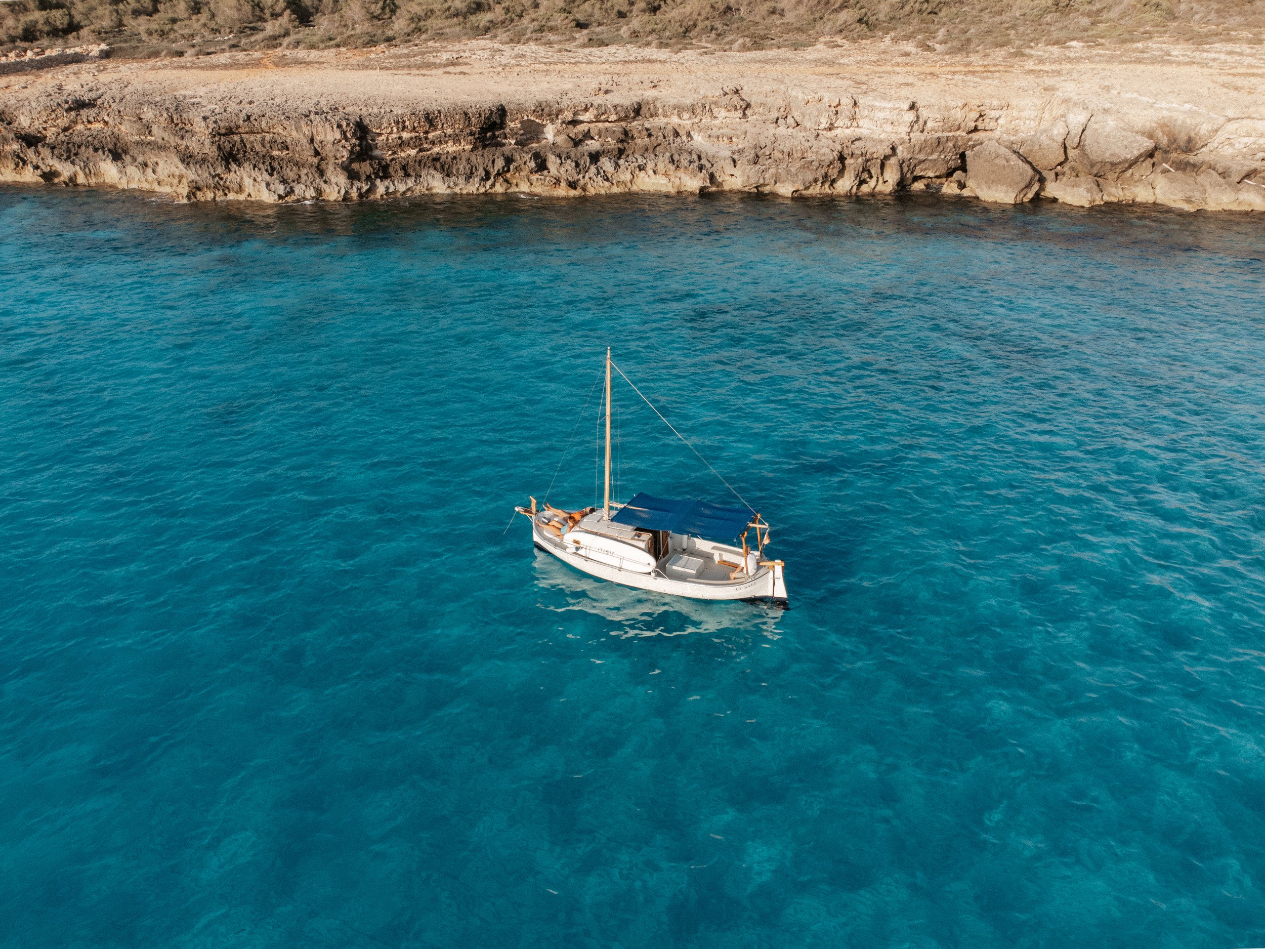 Private boat anchored off the coast of Menorca at sunset