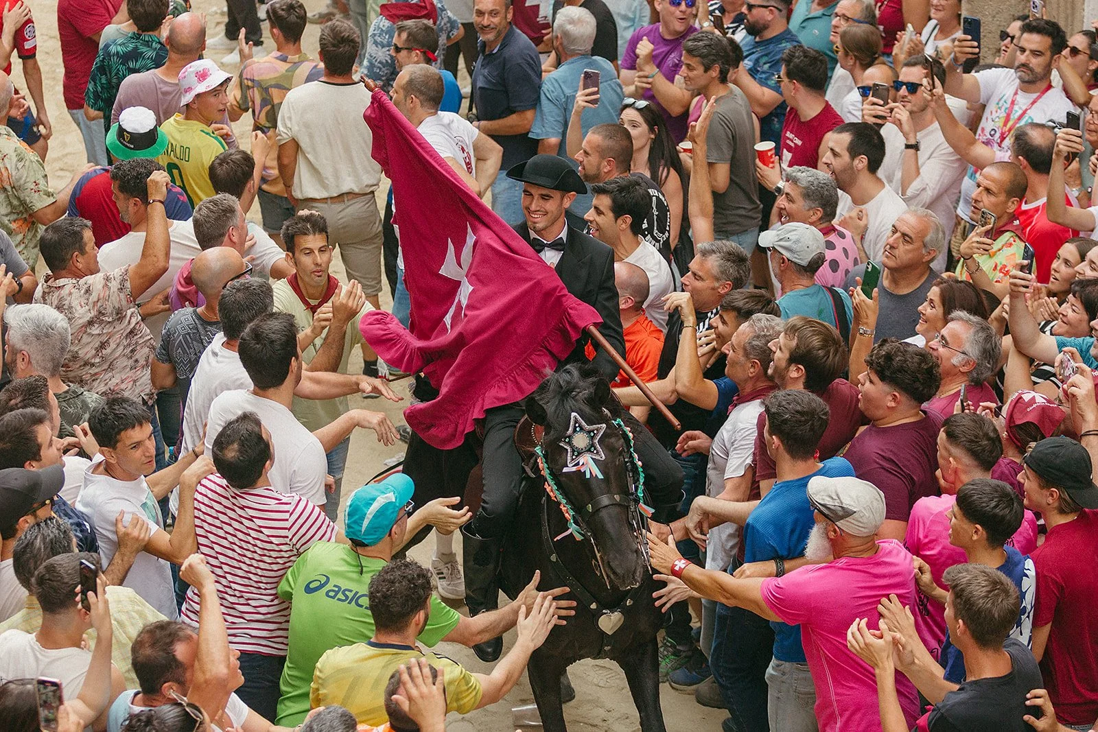 Caixer Fadrí on a horse, holding the flag at the Sant Joan festival in Ciutadella, Menorca, part of the traditional Caragol and procession