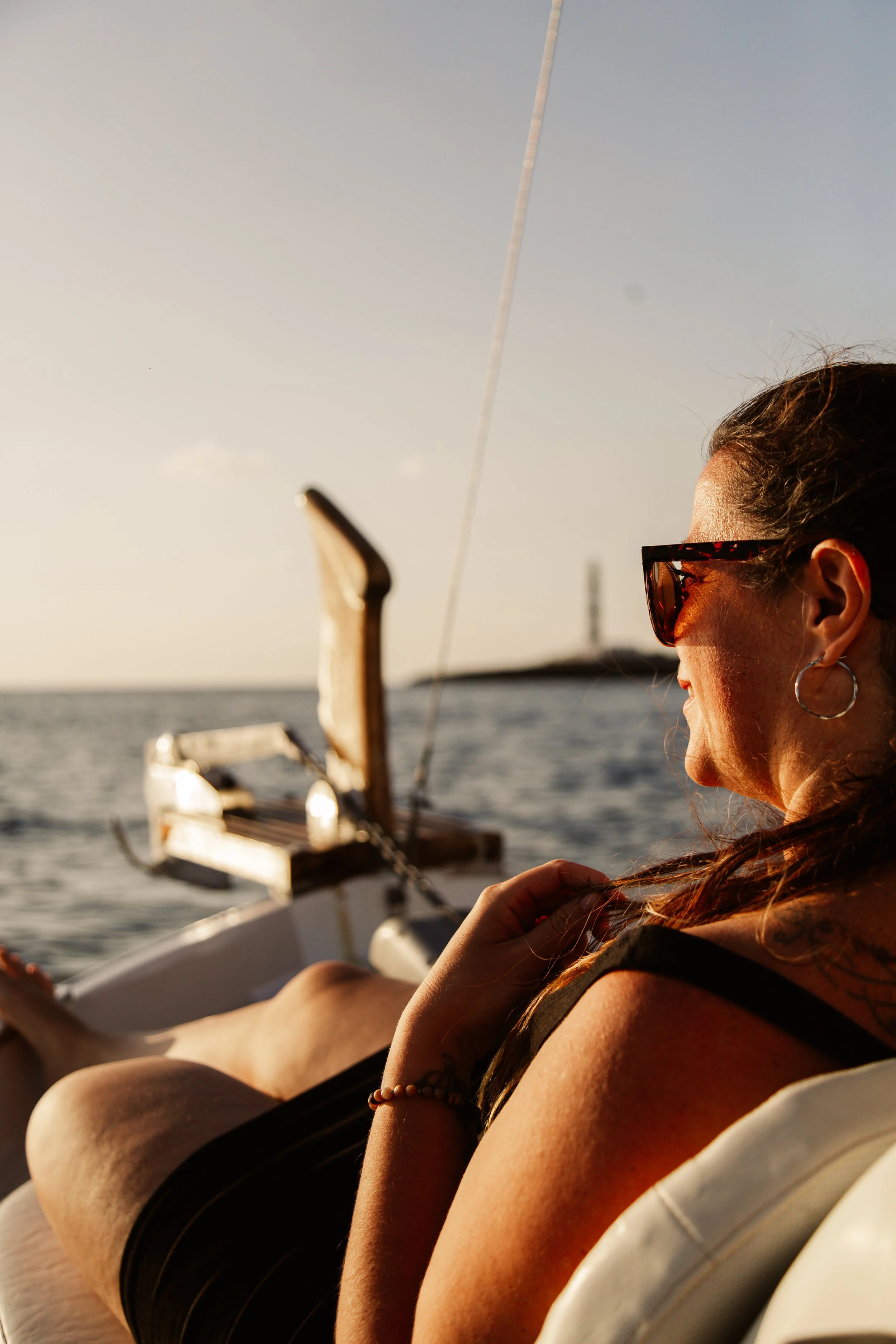 Relaxing on deck of a traditional Llaut while the sun sets at Cap d’Artrutx, Menorca