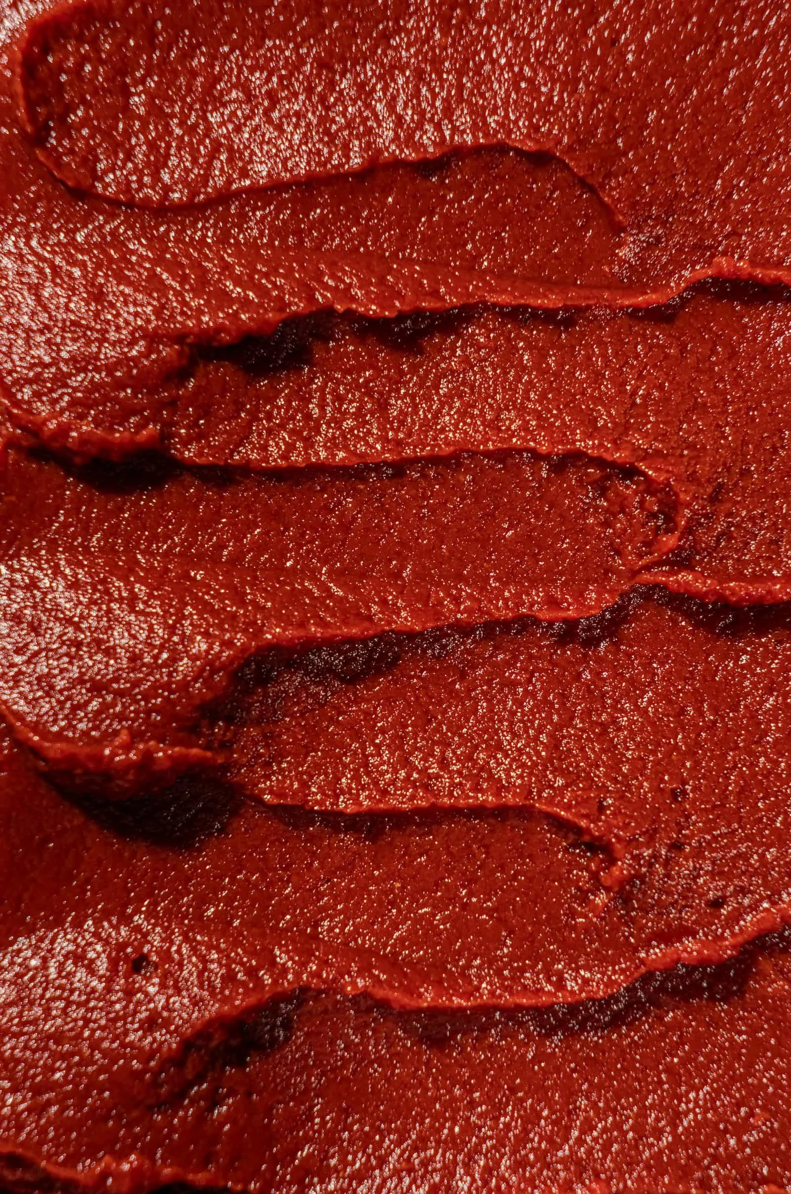Close-up of multiple layers of red pizza sauce.