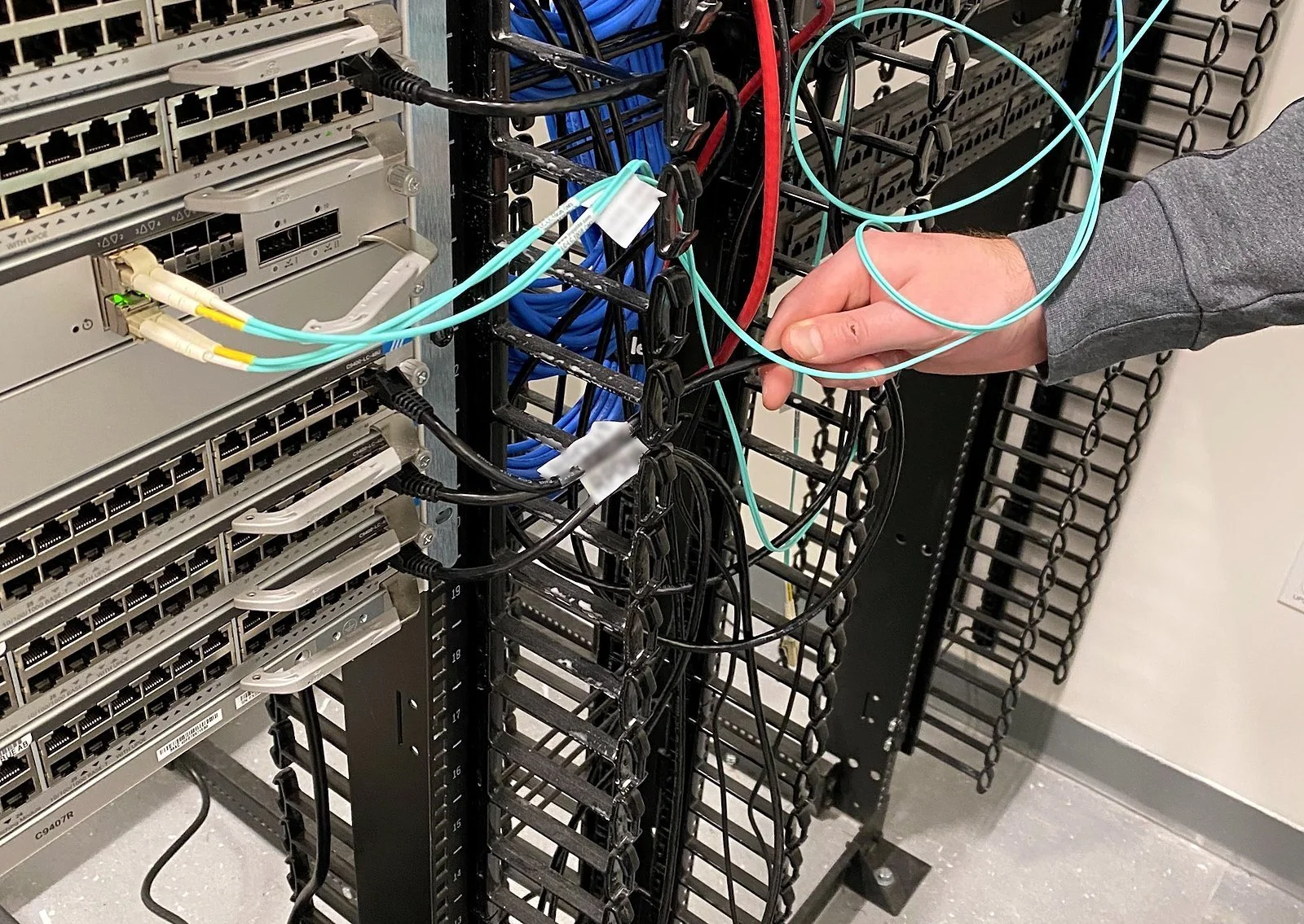 Technician patching cables in an enterprise network rack