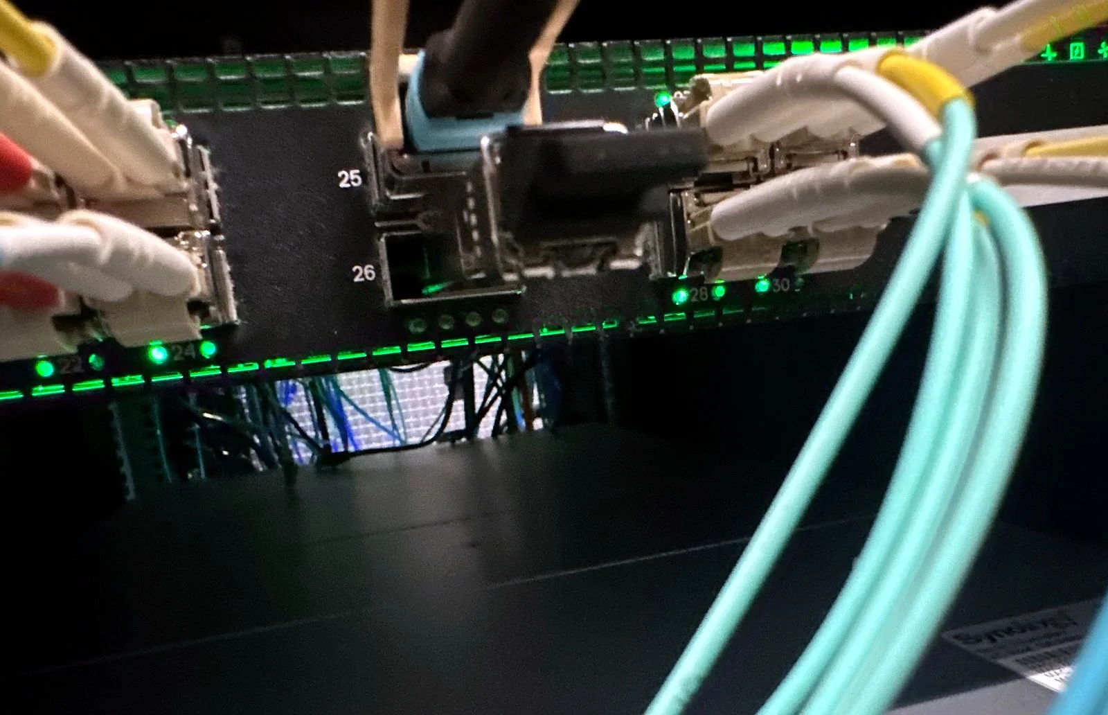 Aqua multimode fiber seated into switch ports with link lights on