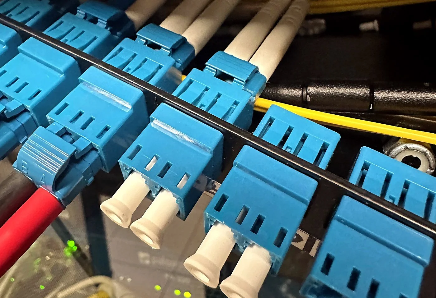 LC duplex fiber connectors and dust caps on a fiber patch panel