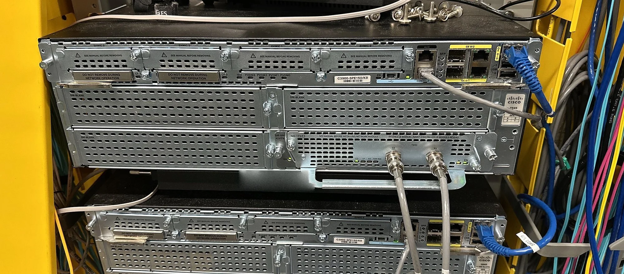 Rack of Cisco routers with dressed network cabling