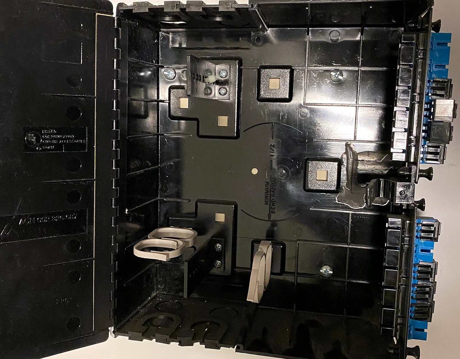 Wall-mounted fiber enclosure opened for termination
