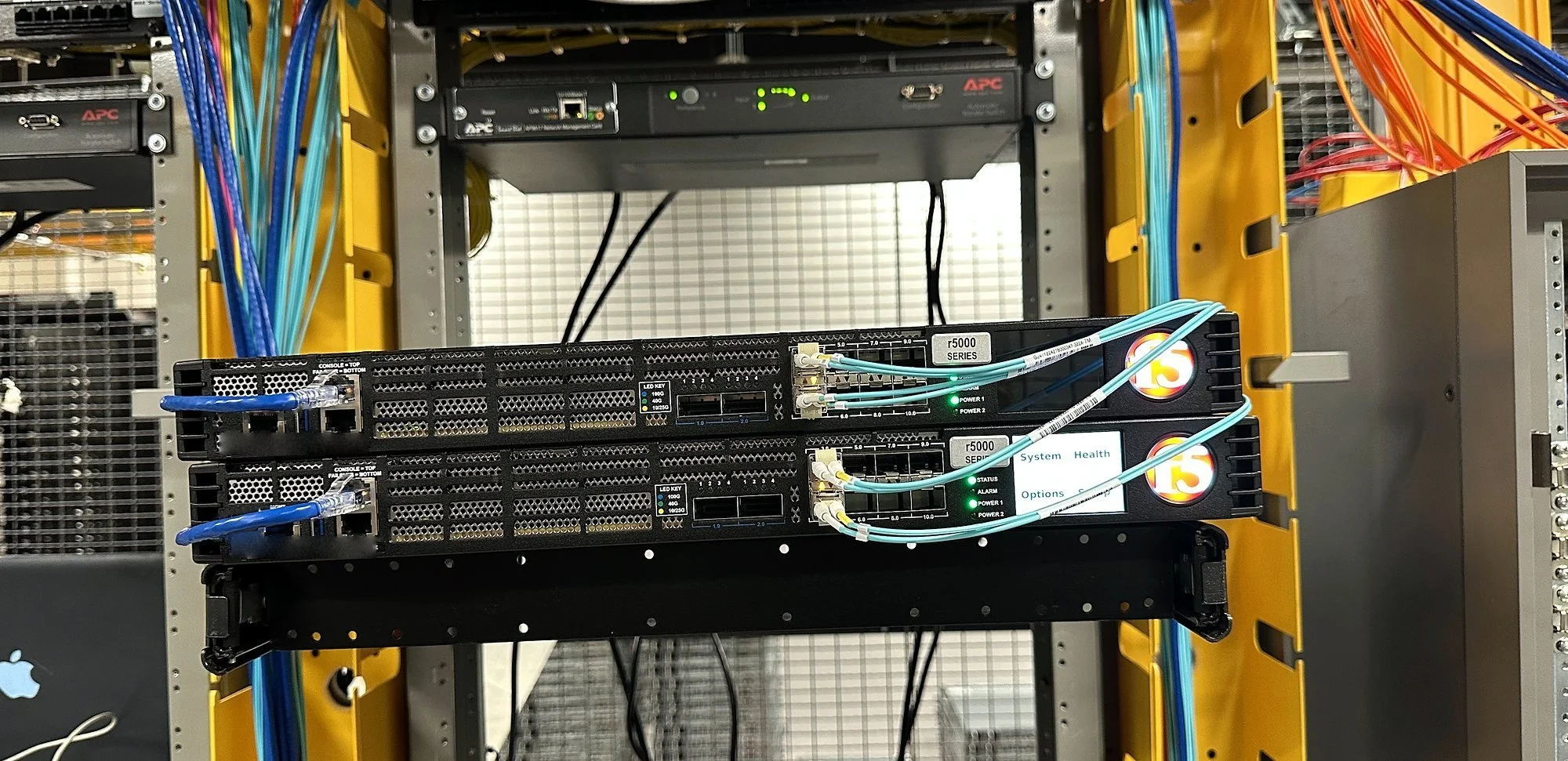 Two-post rack with orange fiber patching between devices