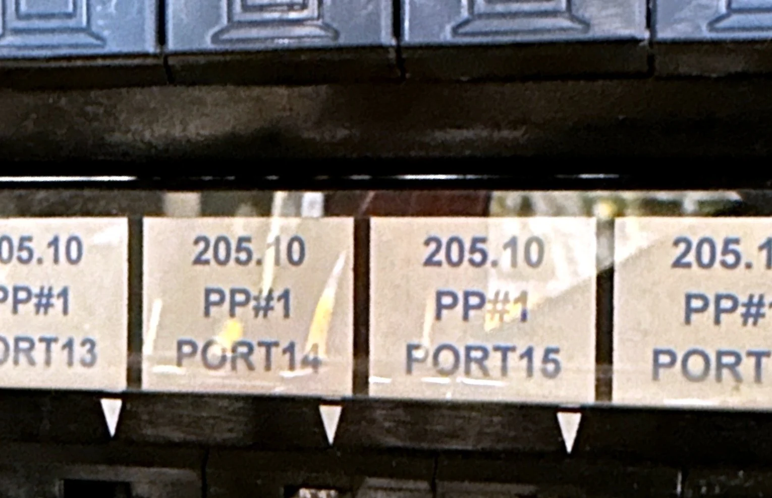 Patch panel ports labeled by cabinet and panel for cable tracing