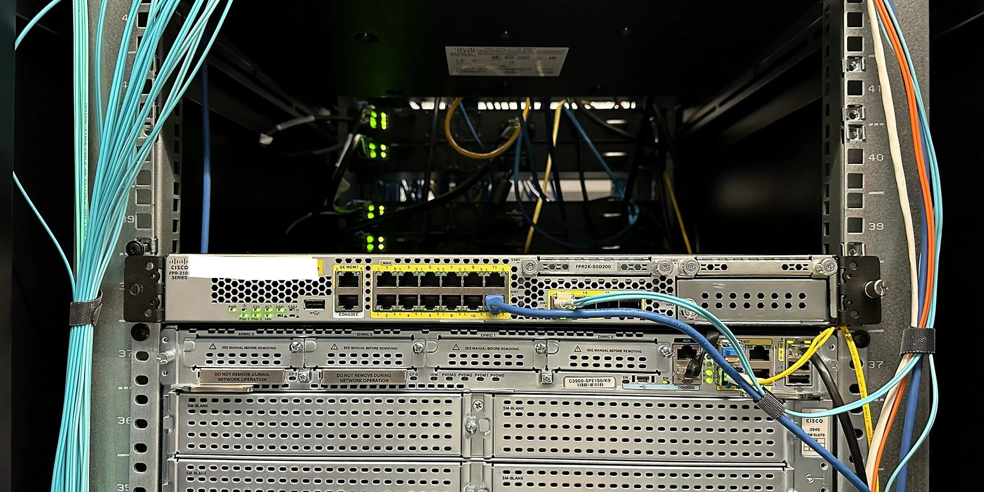 Cisco router powered up in a network rack with fiber patching