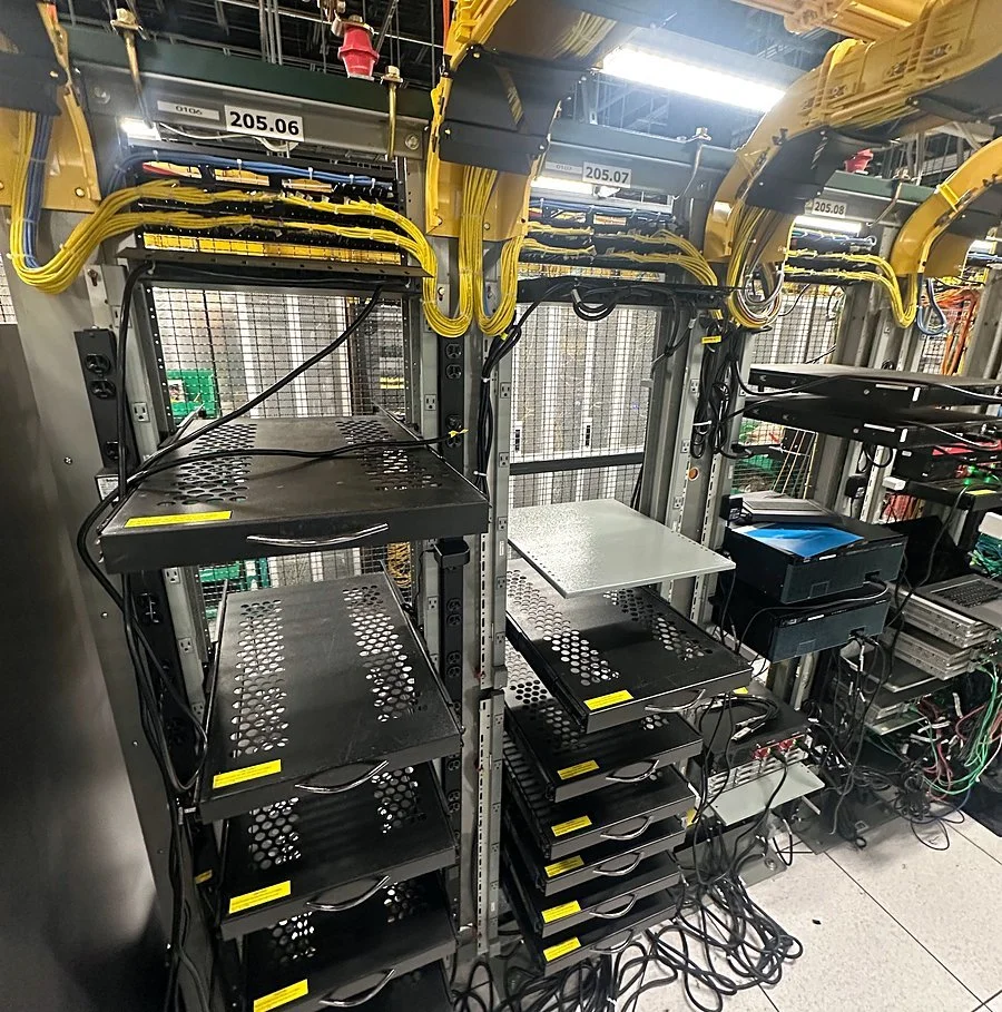 Colocation cabinets under overhead yellow fiber raceway in a data center