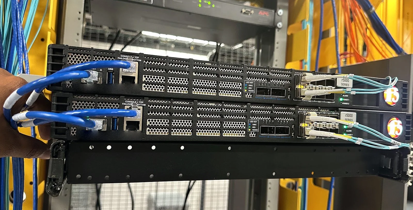 Switch in a two-post rack with blue Cat6 patching dressed to the ports