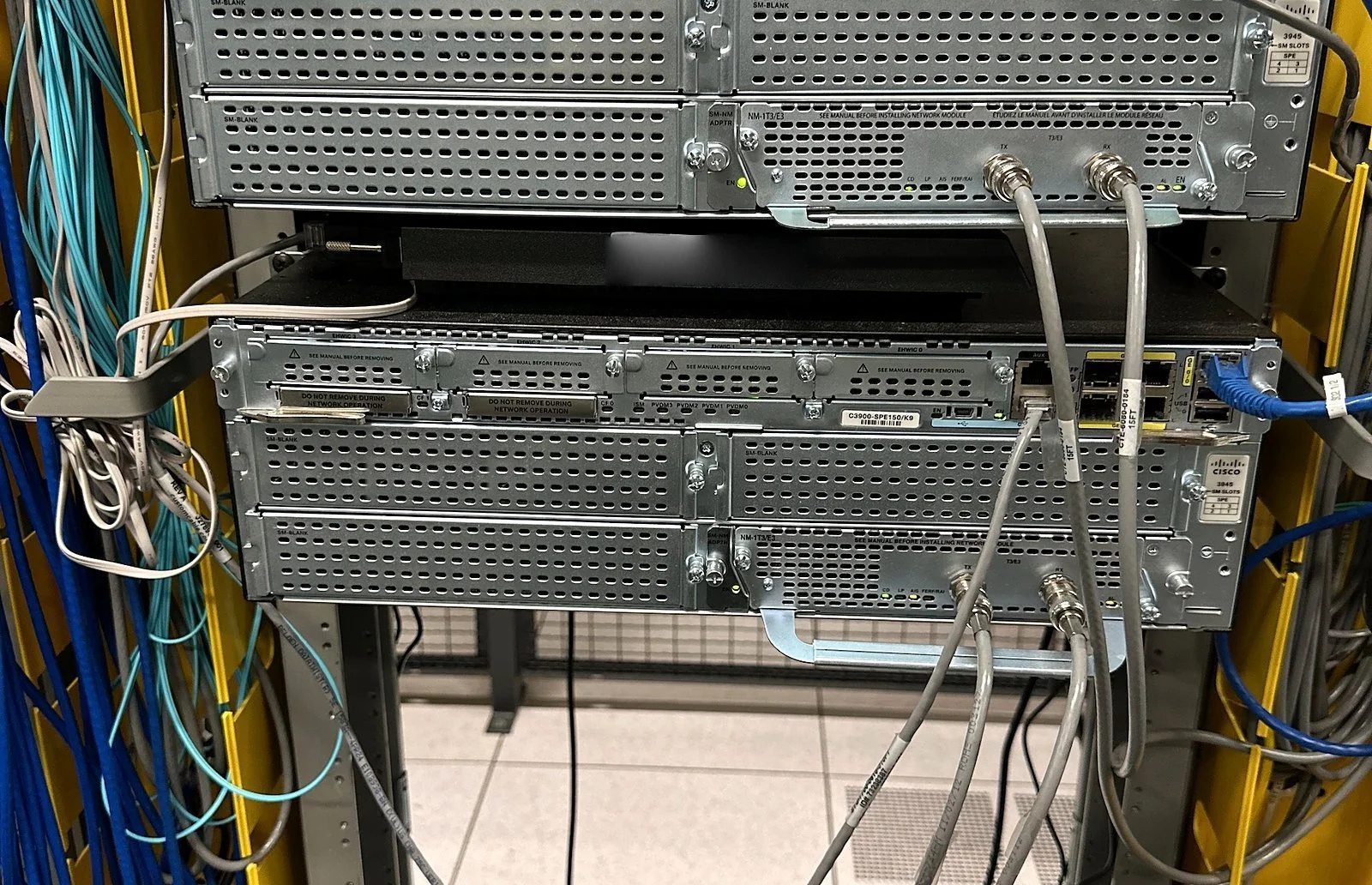 Cisco routers installed in a rack with patch cables