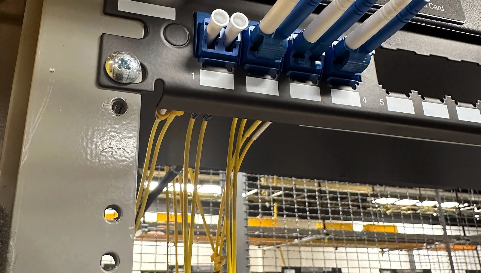 Rear of a network rack with LC fiber and power cabling during smart hands work