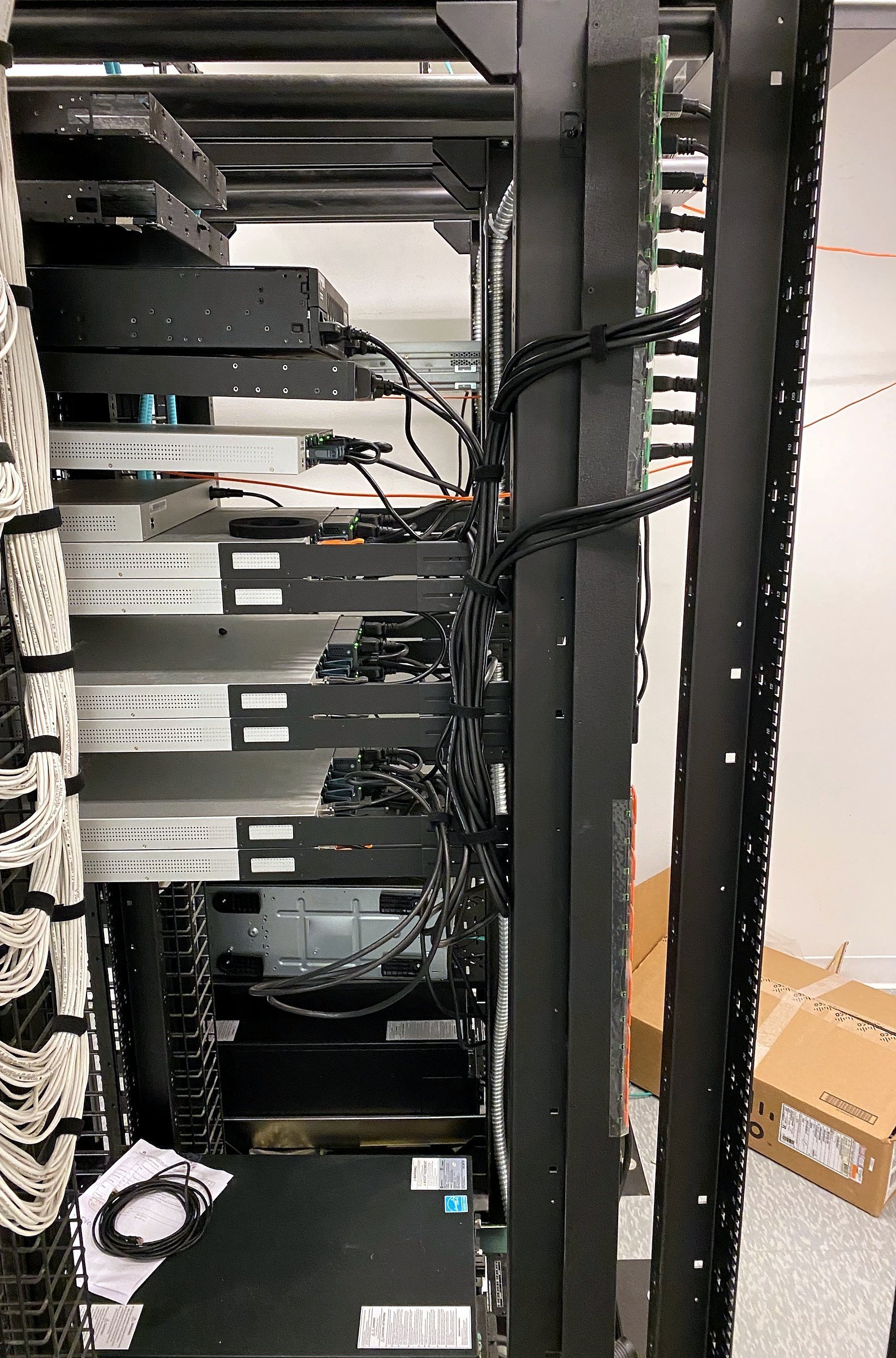 Rear of a network rack with cabling dressed in vertical managers