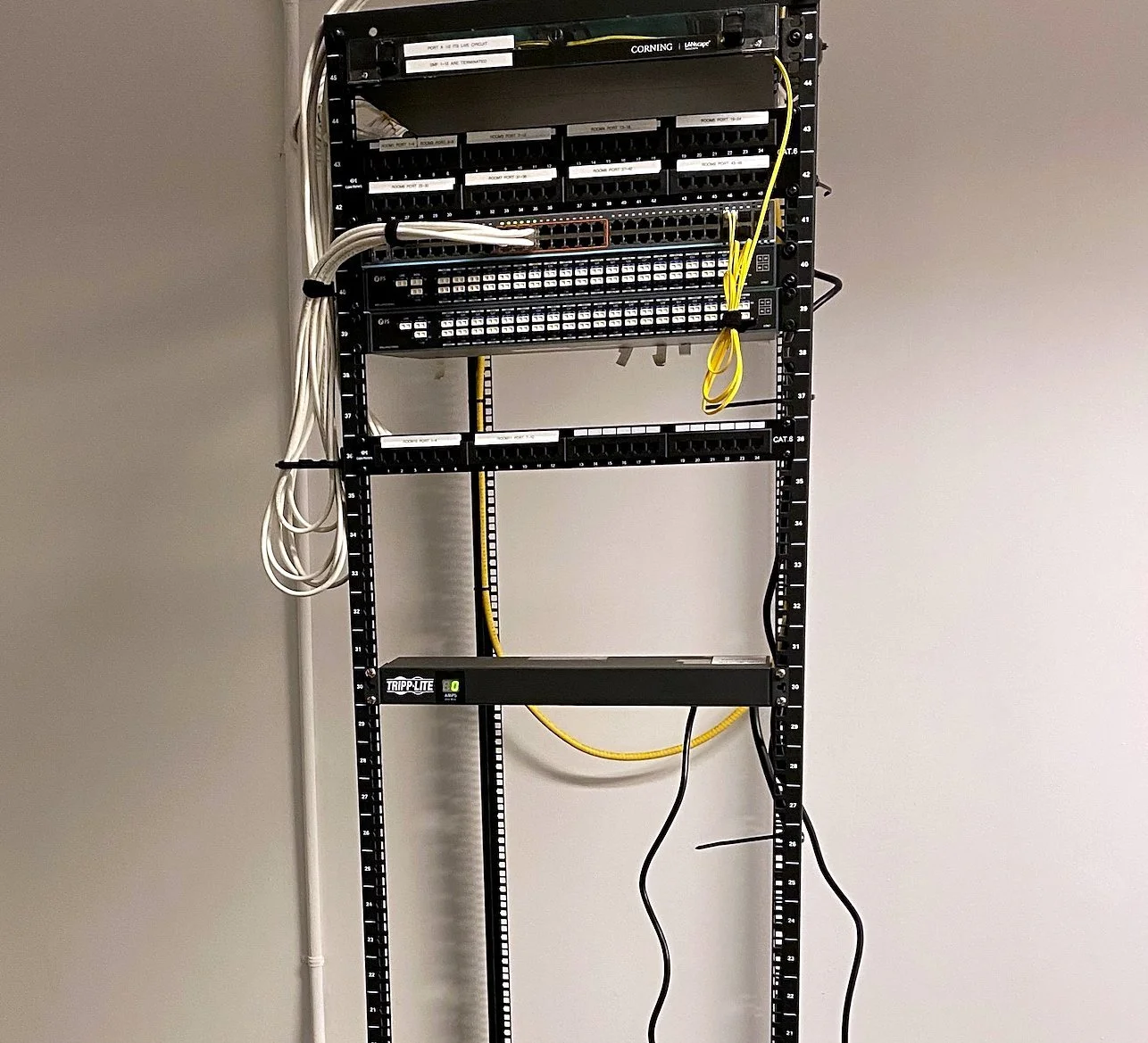 Two-post rack with patch panels installed in a network closet