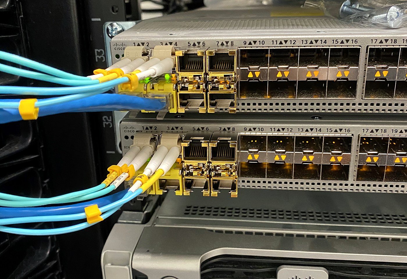 Cisco switches patched with aqua multimode fiber and LC connectors in a data center rack