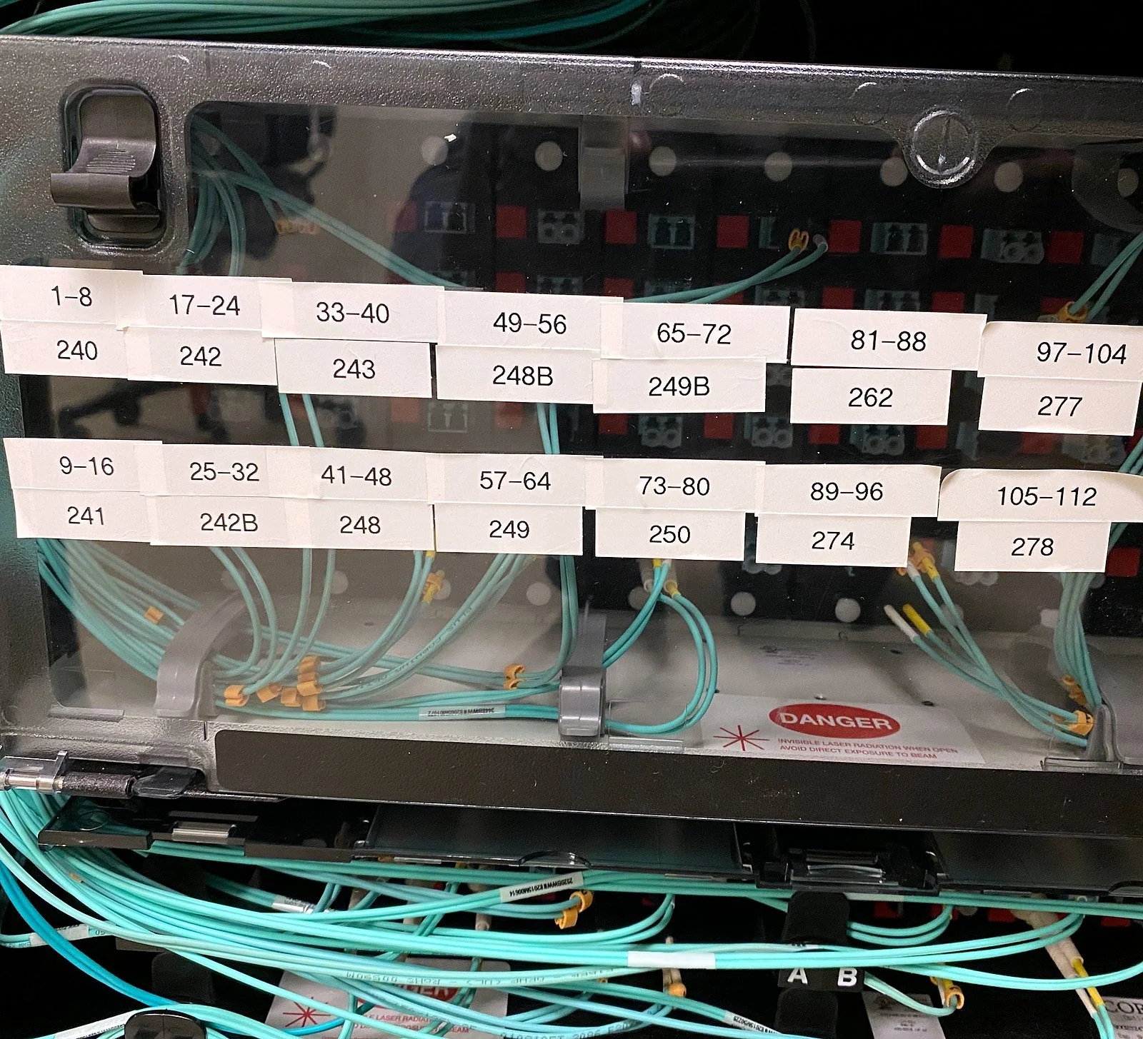 Fiber enclosure with labeled cassette port ranges and aqua multimode jumpers