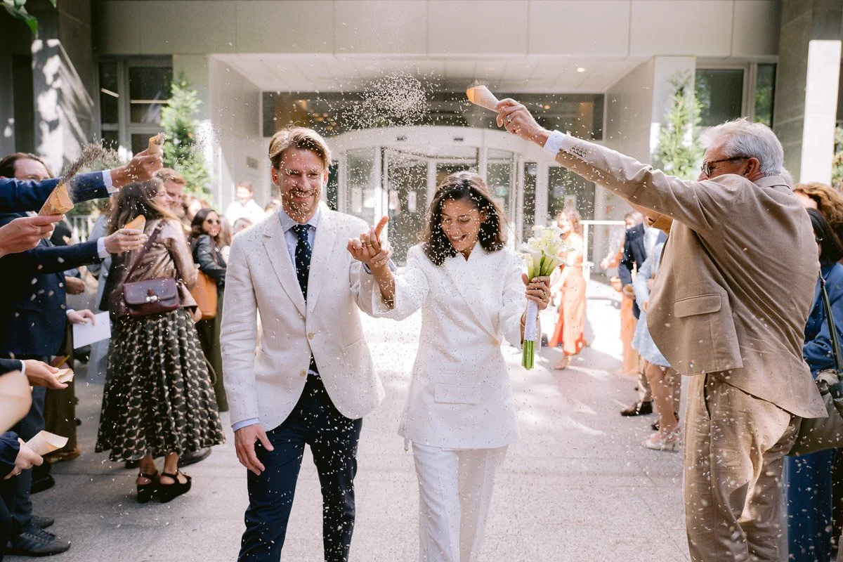 Sortie de la Mairie du 17ème arrondissement de Paris : les mariés sous une pluie de confettis. Reportage photo professionnel.