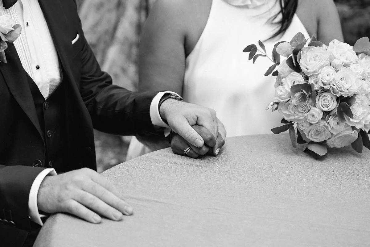 Les mariés main dans la main, un instant d’émotion juste avant la signature de l’acte de mariage civil lors d’une cérémonie civile en extérieur en Île-de-France.